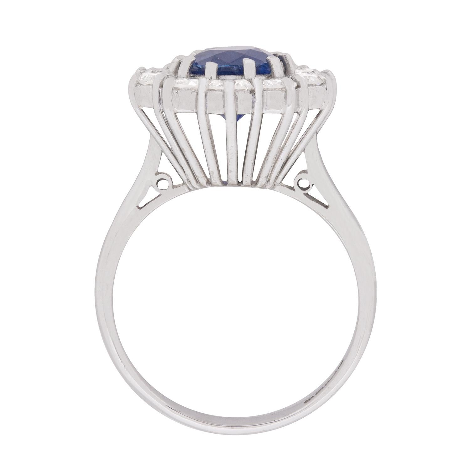 This typically vintage ring features a sapphire as the star of the show, with an impressive blue shine. It weighs 1.75 carat and is haloed by ten round brilliant diamonds. The diamonds have a combined weight of 1.50 carat and are of high quality,