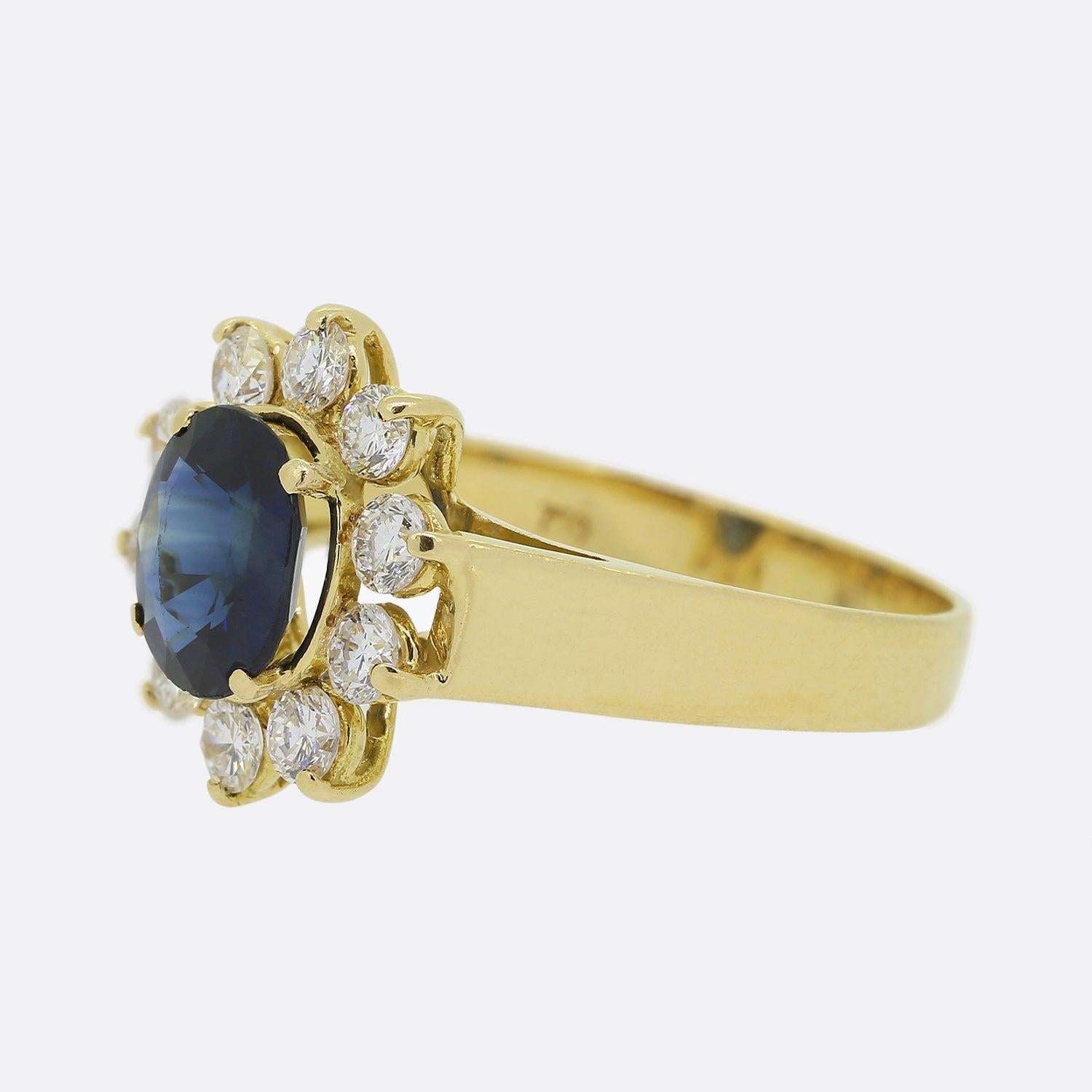Here we have an 18ct yellow gold sapphire and diamond cluster ring. An oval shaped sapphire possessing a wonderfully iridescent twilight blue colour tone sits claw set at the centre of the piece. This principle stone is then circulated and