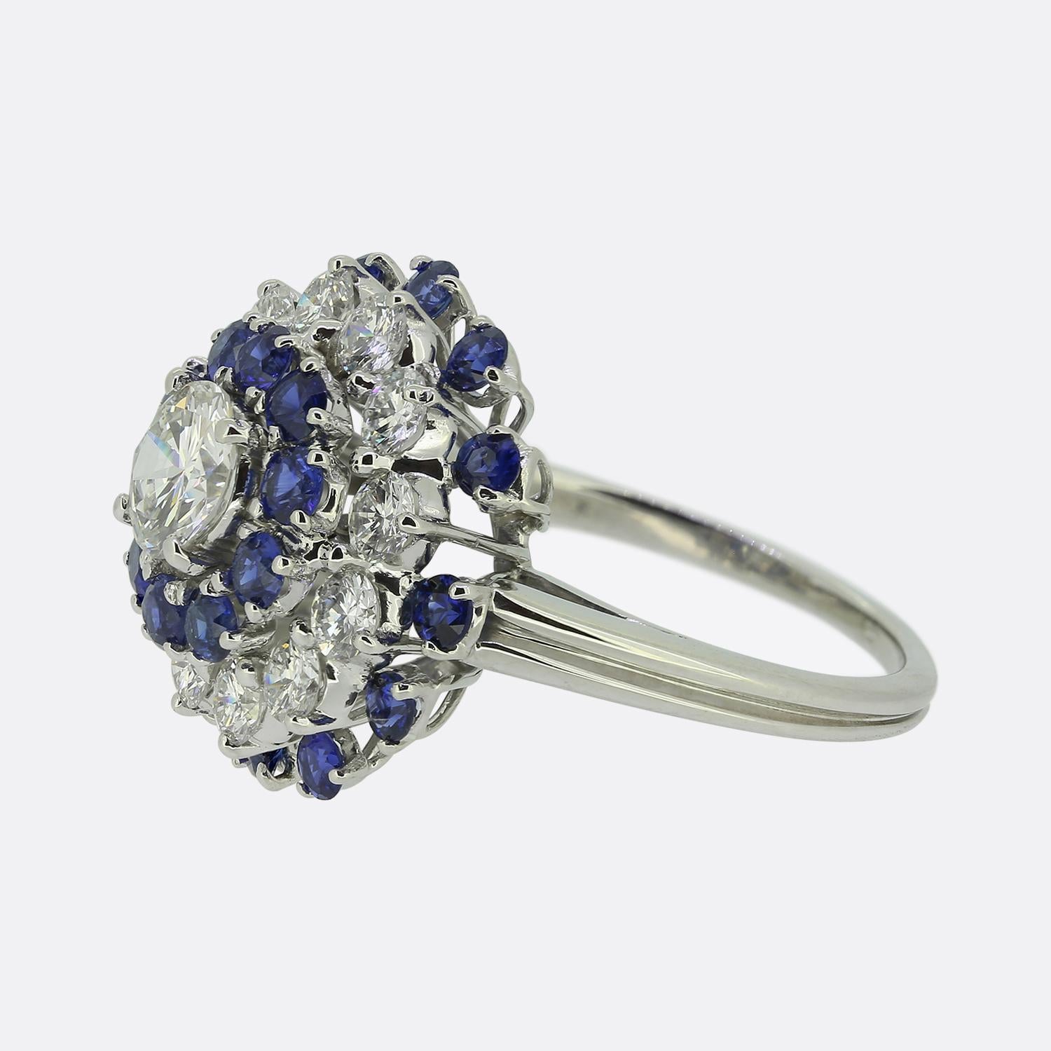 Ecco un delizioso anello a grappolo multistrato. Realizzato in platino, questo gioiello presenta un singolo diamante rotondo taglio brillante da 0,50 carati al centro del quadrante. Questa pietra principale si trova da sola e orgogliosa in una