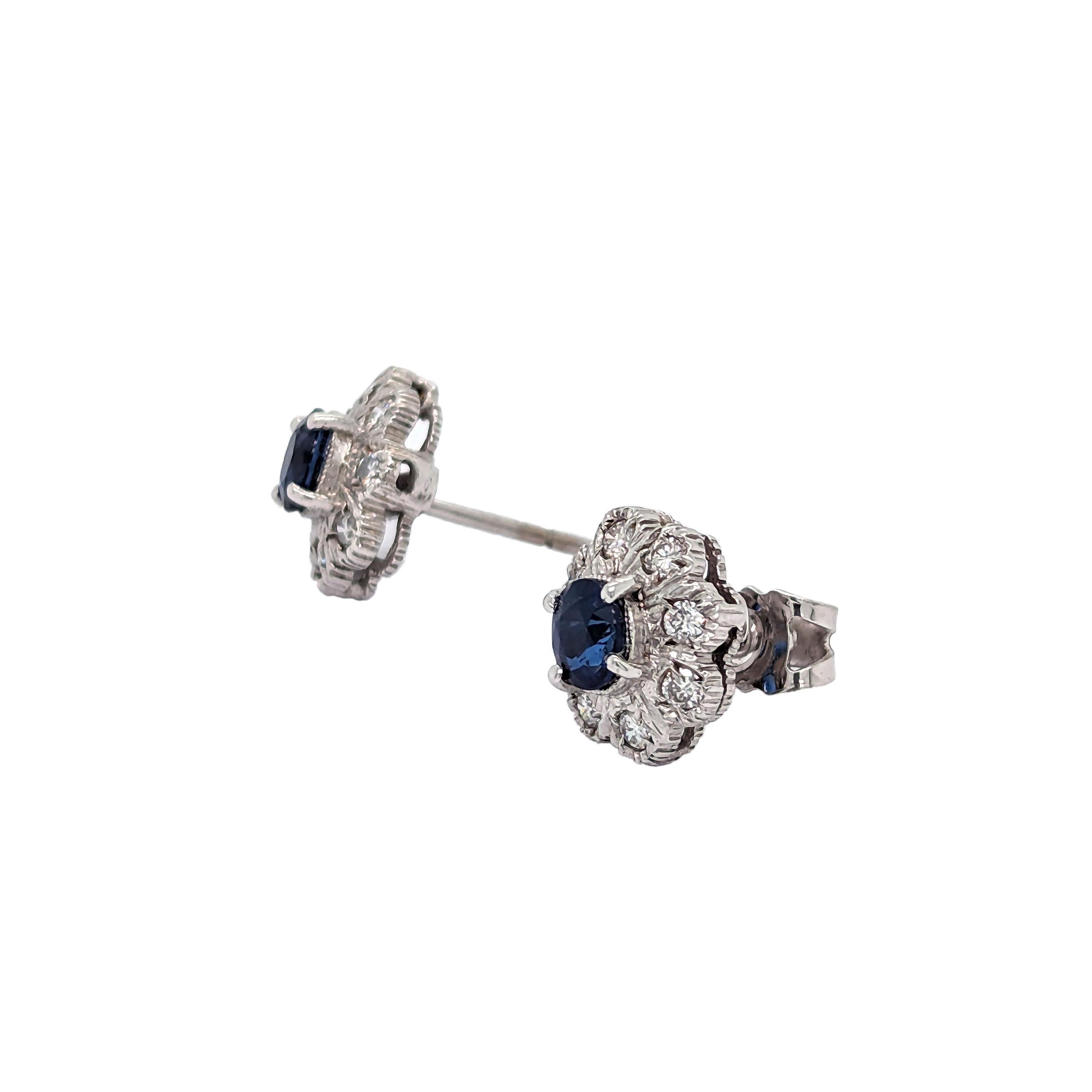 A pair of sapphire and diamond cluster stud earrings, with an oval faceted sapphire in each centre, surrounded by eight, round brilliant-cut diamonds, in illusion settings, mounted in white gold, with post and butterfly fittings, circa 1960.