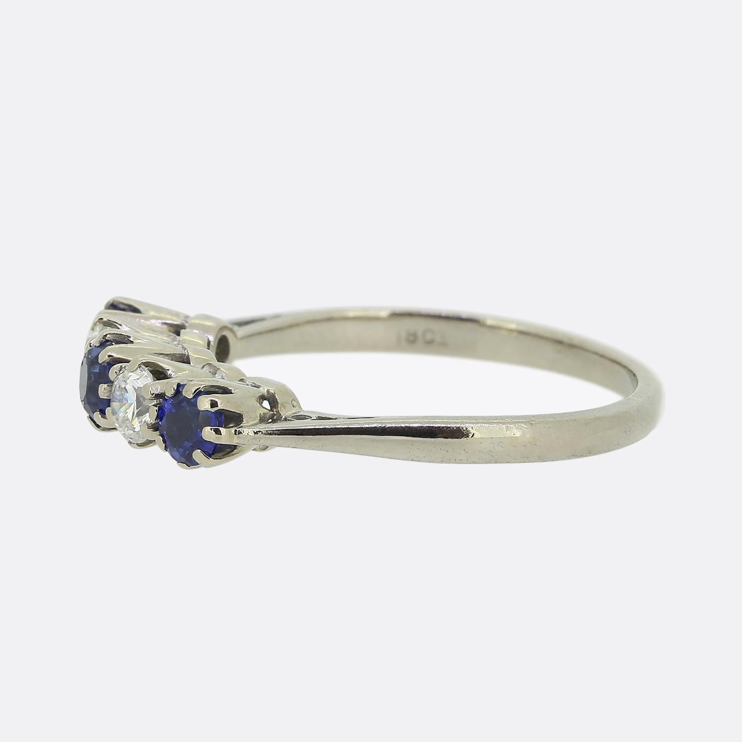 Here we have a classically styled sapphire and diamond five-stone ring. This vintage piece has been crafted from 18ct white gold and features three round faceted sapphires possessing an electric medium blue colour tone. These perfectly matched