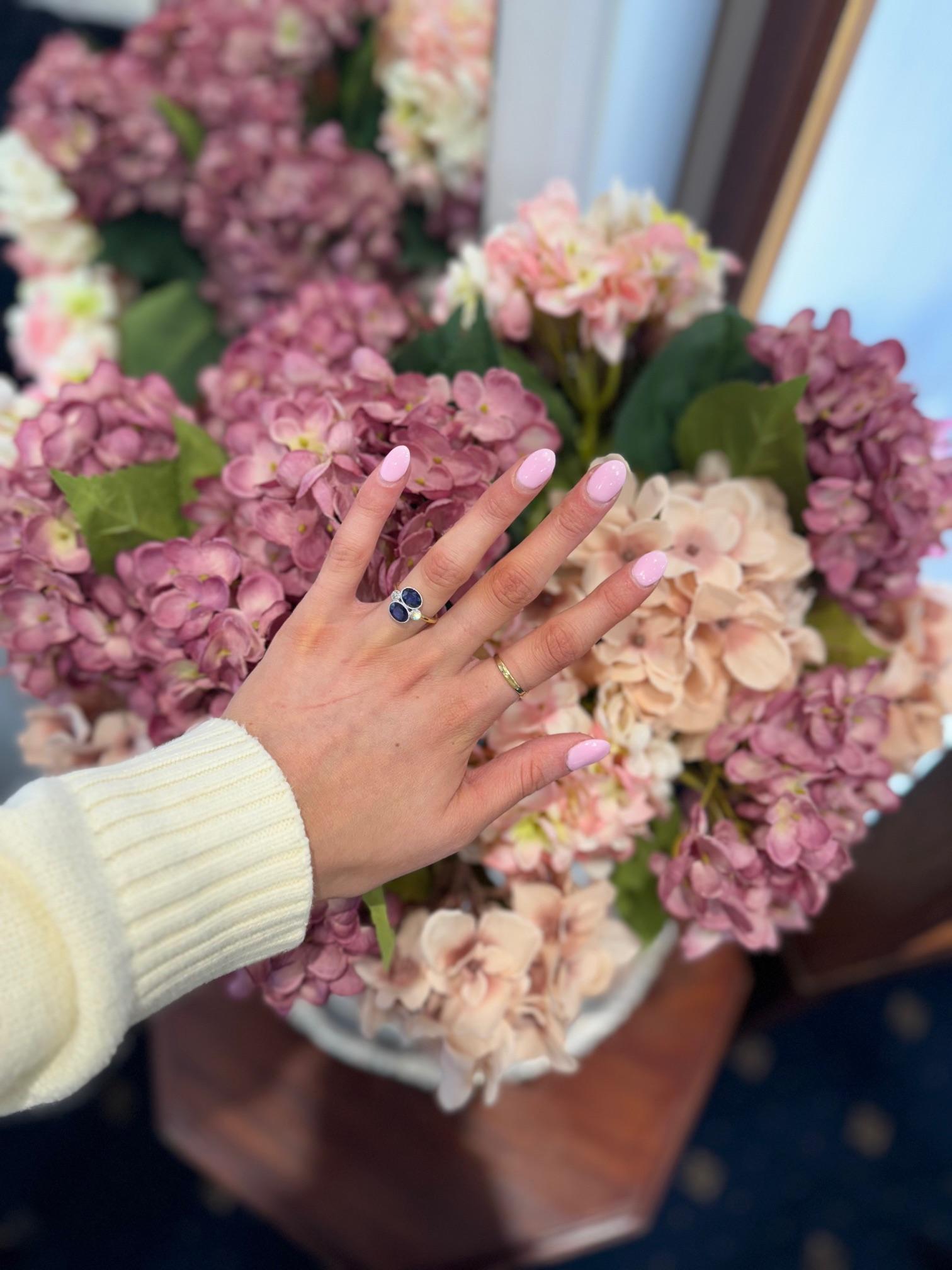 This ring is a beautiful example of vintage jewellery, featuring a combination of sapphires and diamonds with intricate details. Here’s a detailed description:
Ring Design:

Style: Vintage
Setting: Twin East-West
Finish: Bezel Set with a millegrain
