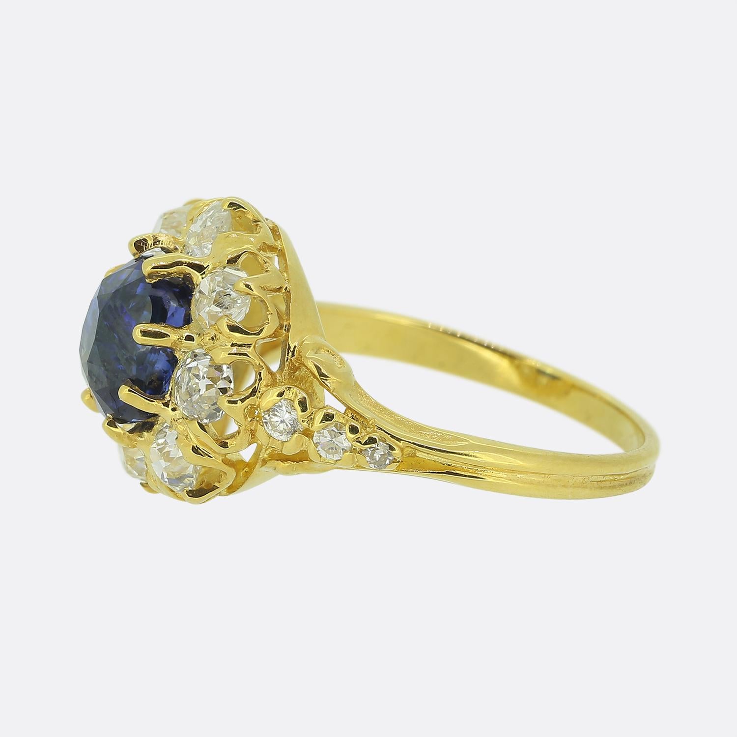 This is a wonderful 18ct yellow gold sapphire and diamond cluster ring. The ring features a central mid to dark blue sapphire which is surrounded by eight old cut diamonds. The diamonds are a bright white colour perfectly complimenting the