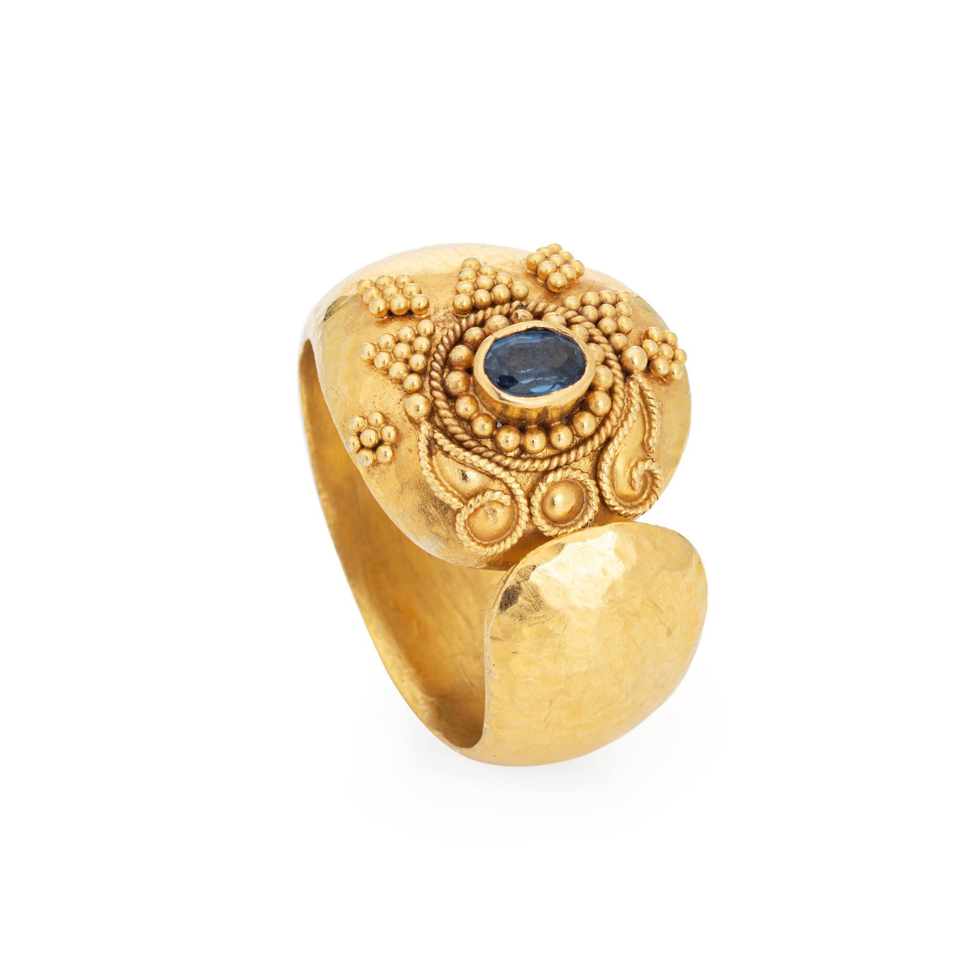 Stylish vintage sapphire ring crafted in 22 karat yellow gold. 

Small blue sapphire measures 4mm x 3mm. The sapphire is in very good condition and free of cracks or chips. 

The distinct hand-made ring in bright buttery 22k yellow gold features