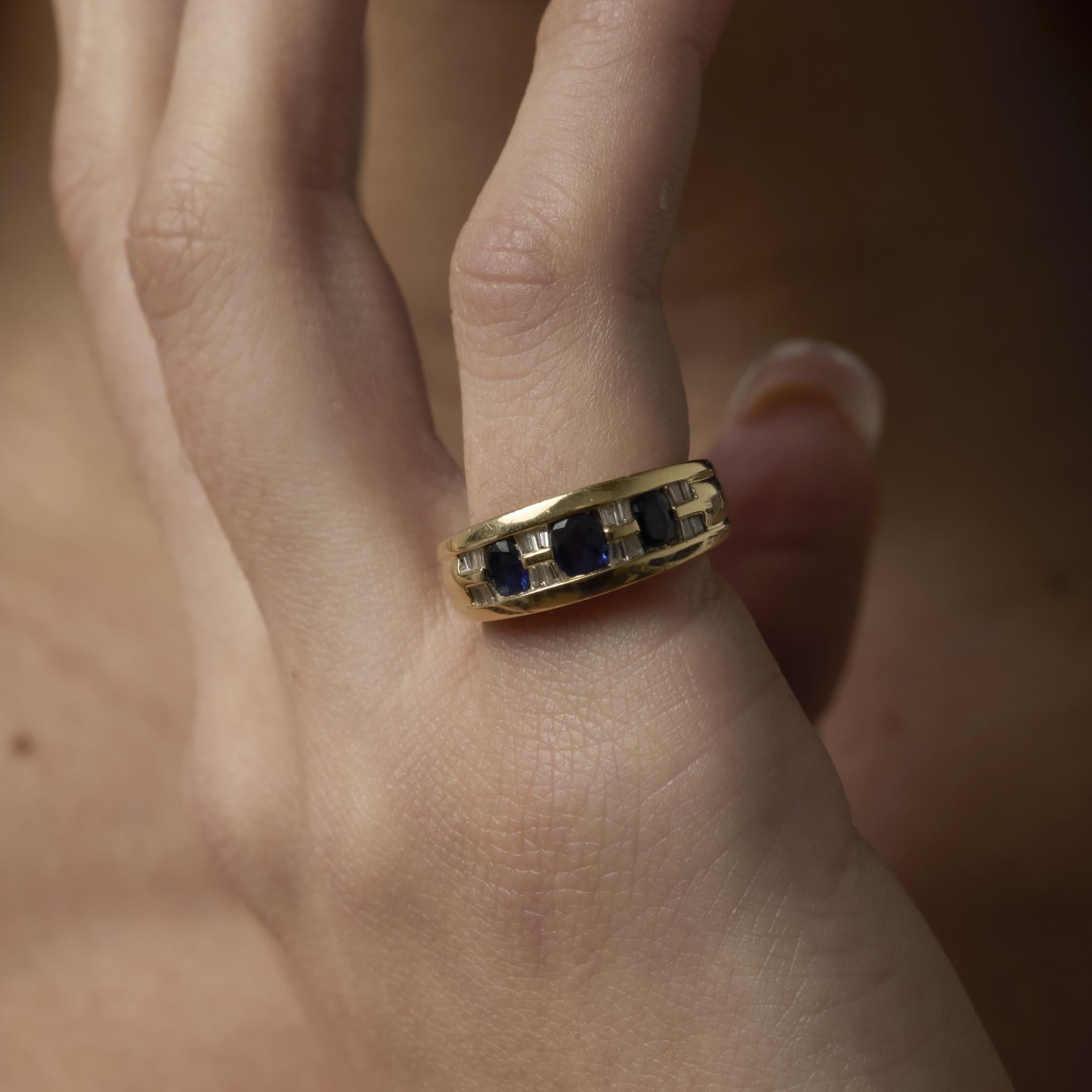 Charmante bague vintage en or jaune 14k sertie de 0,60 carats de saphirs bleus, accentués par 0,20 carats de diamants baguettes effilés pour une élégance classique.