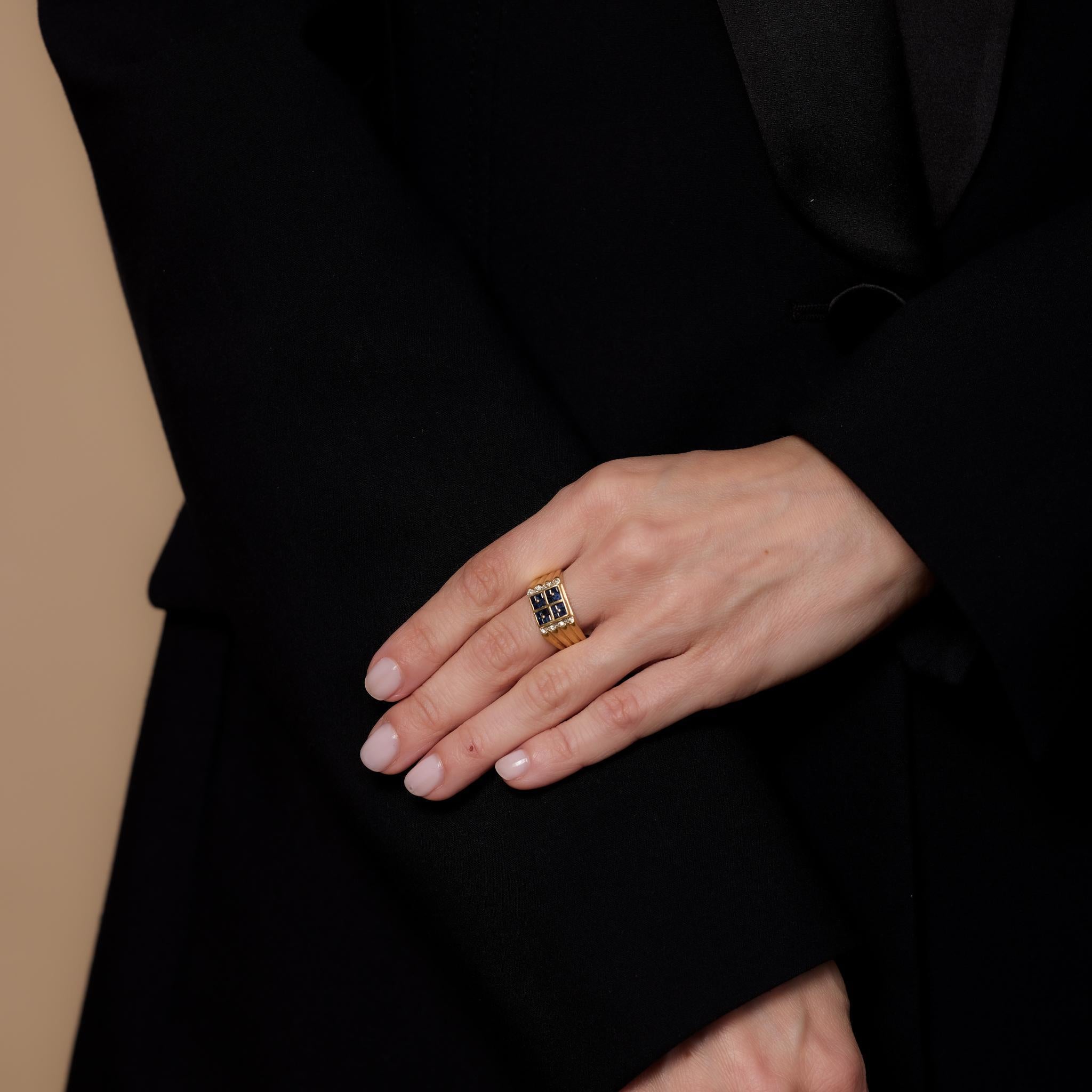 Cette bague vintage en or jaune 18k présente 16 saphirs bleus de taille carrée totalisant environ .60 carats, accentués par 8 diamants ronds de taille brillant pesant .05 carats, de couleur H, et de pureté SI. Fabriqué dans les années 2000, il est