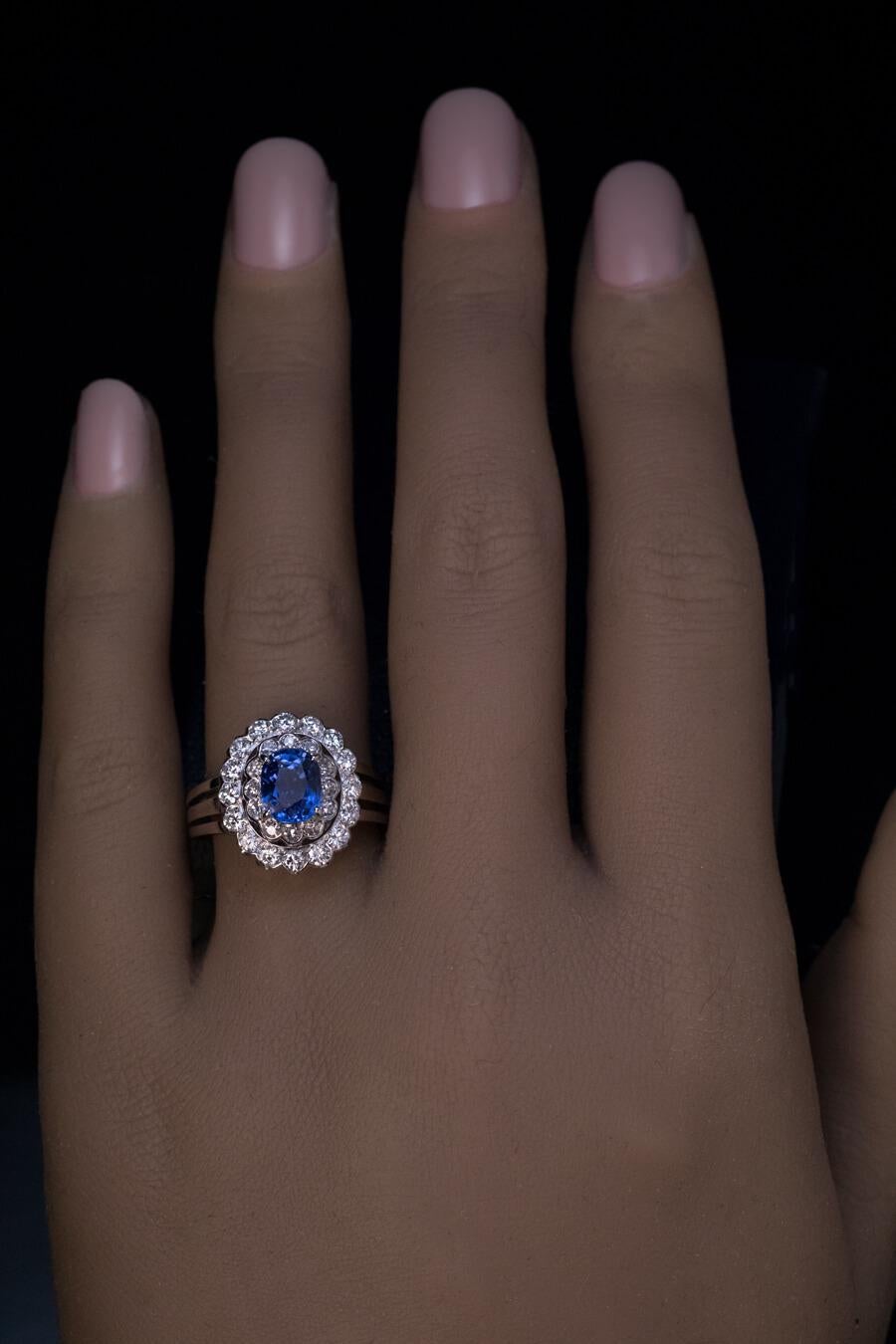Circa 1950s  The double halo ring is crafted in 14K white gold. It’s centered with a vivid blue sapphire (approximately 1.41 ct, likely of Ceylon origin) framed by a row of single cut diamonds (G-H color, VS1-SI1 clarity) and a row of brilliant cut