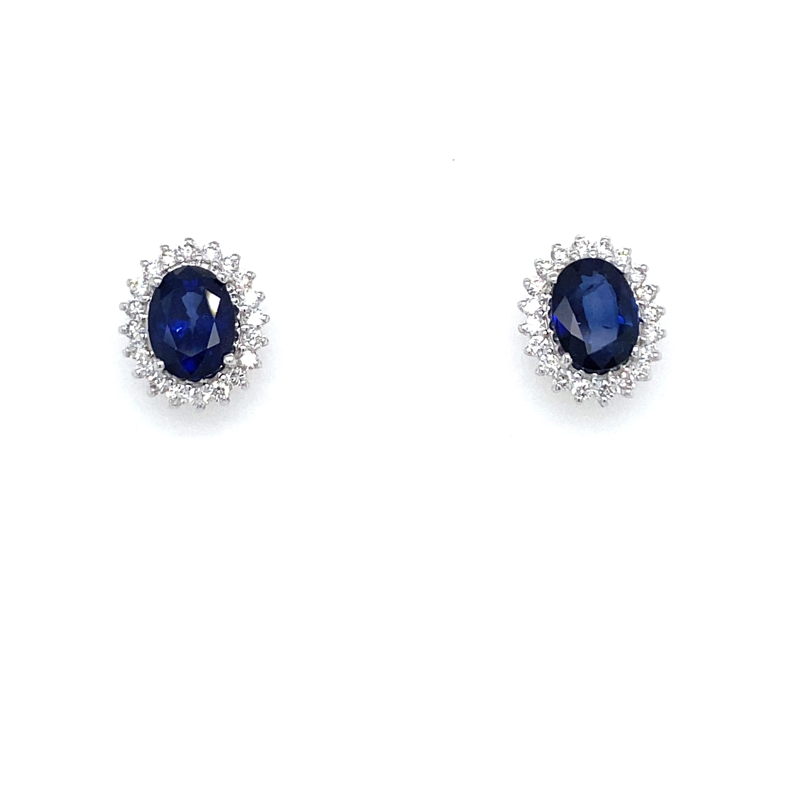 Gorgeous pair of vintage Sapphire diamond cluster earrings handcrafted in solid 18k white Gold. 

They are set with Bright Natural Sapphire in the center, total weight 2.41 carat, and surrounded by an halo of colorless sparkling Round Brilliant cut