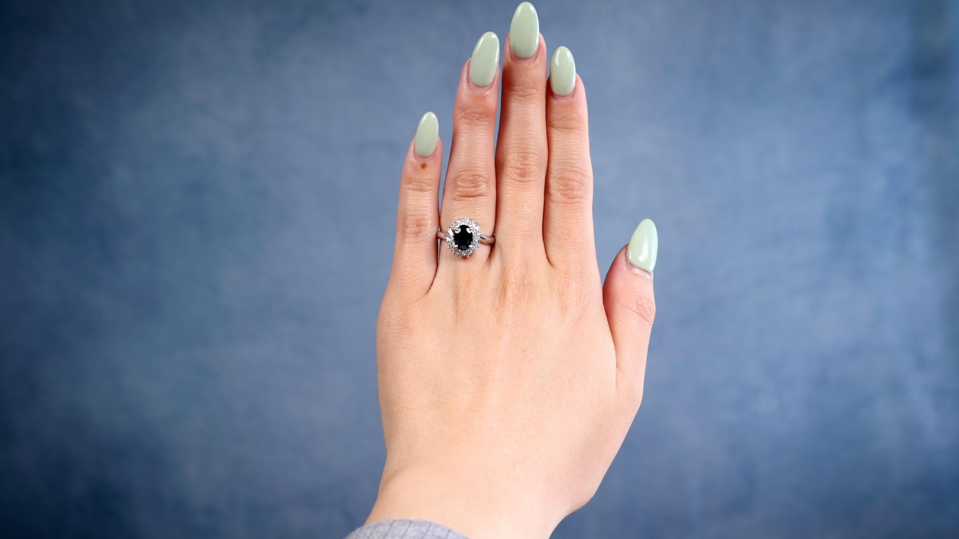 Ein Vintage Saphir Diamant Platin Cluster Ring. Mit einem ovalen Saphir im Mischschliff von 1.37 Karat. Akzentuiert durch vier spitz zulaufende Baguette-Diamanten und 24 runde Diamanten im Brillantschliff mit einem Gesamtgewicht von 0,35 Karat,