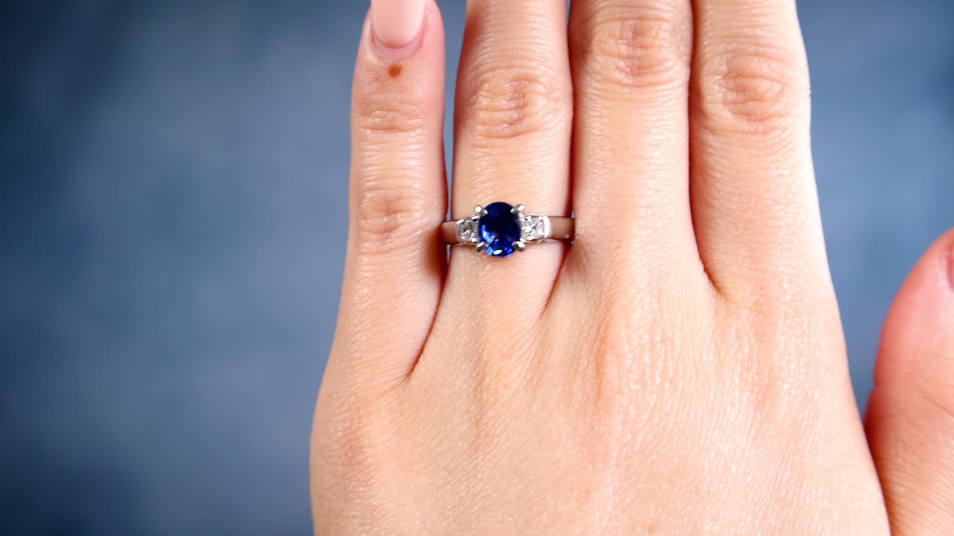 One Vintage Sapphire Diamond Platinum Three Stone Ring. Featuring one oval mixed cut sapphire of 1.08 carats. Accented by two princess cut diamonds with a total weight of 0.20 carat, graded G-H color, VS clarity. Crafted in platinum with purity mark
