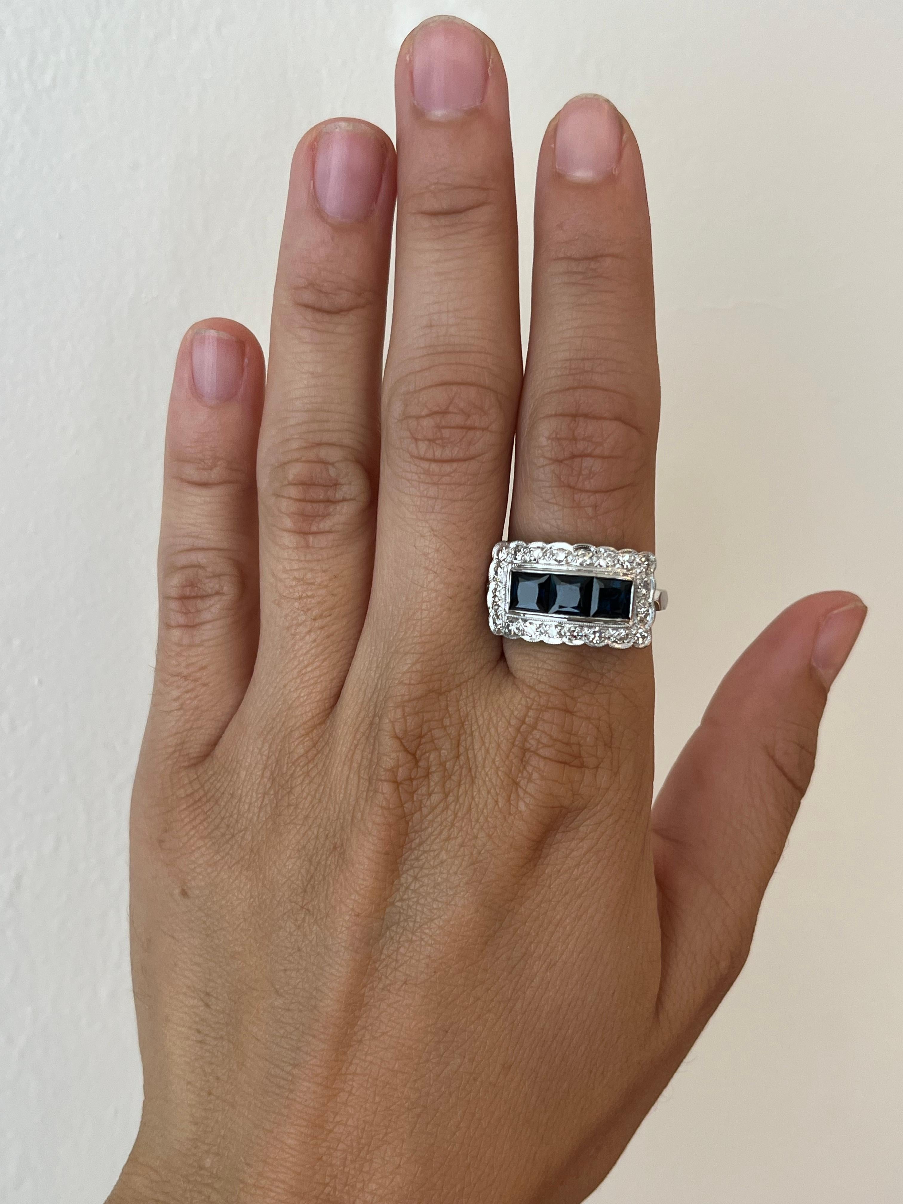 Dieser exquisite rechteckige Vintage-Ring mit Saphiren und Diamanten ist ein zeitloser Schatz aus den 1950er Jahren. Der aus Platin gefertigte Ring zeigt vier atemberaubende Saphire, deren tiefblaue Farbtöne von 20 runden Brillanten ergänzt werden.