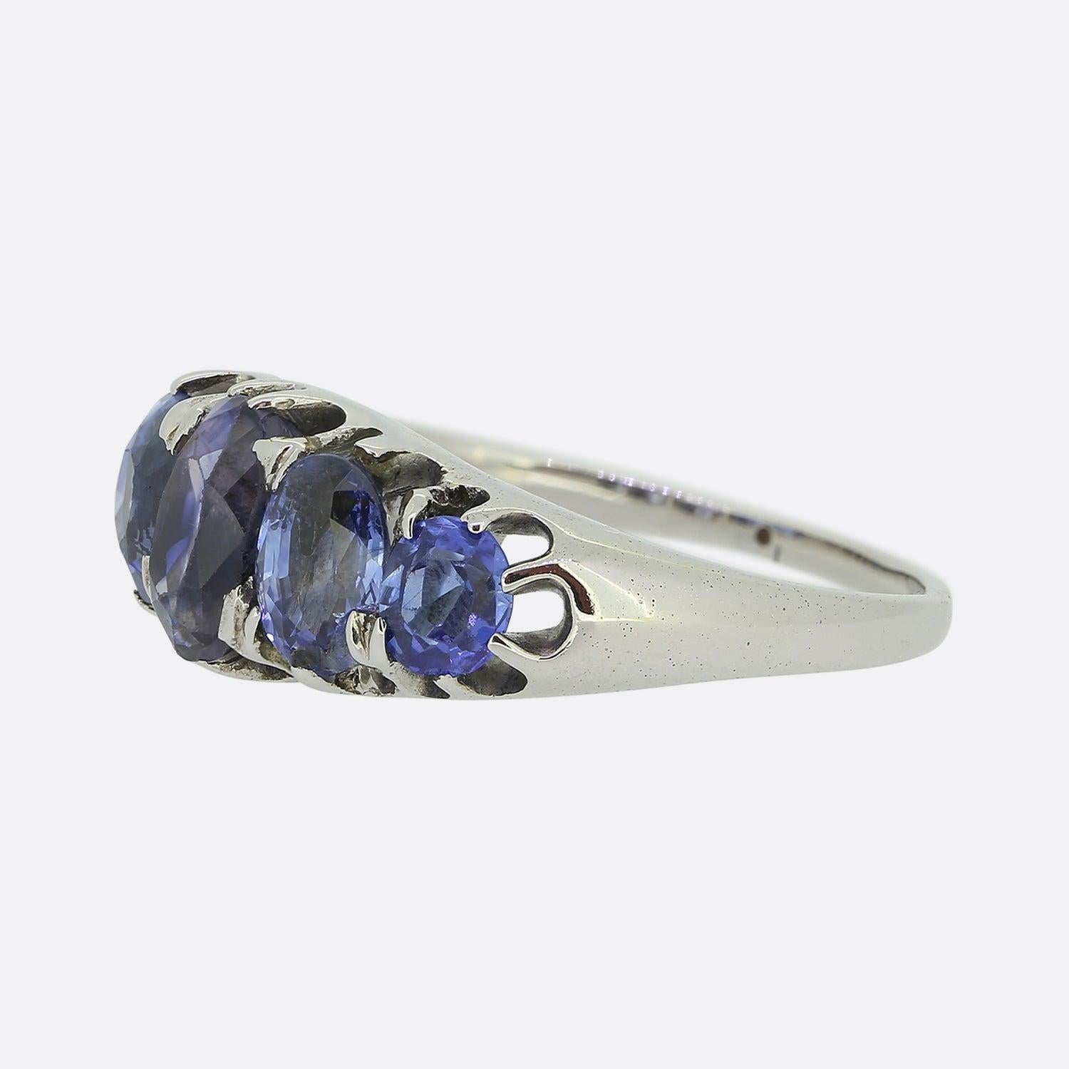 Here we have a vintage platinum ring playing host to five sapphires of differing shapes and sizes. At the centre we find an oval cut sapphire possessing a velvet blue colour tone. This principle stone is then flanked on either side by a slightly
