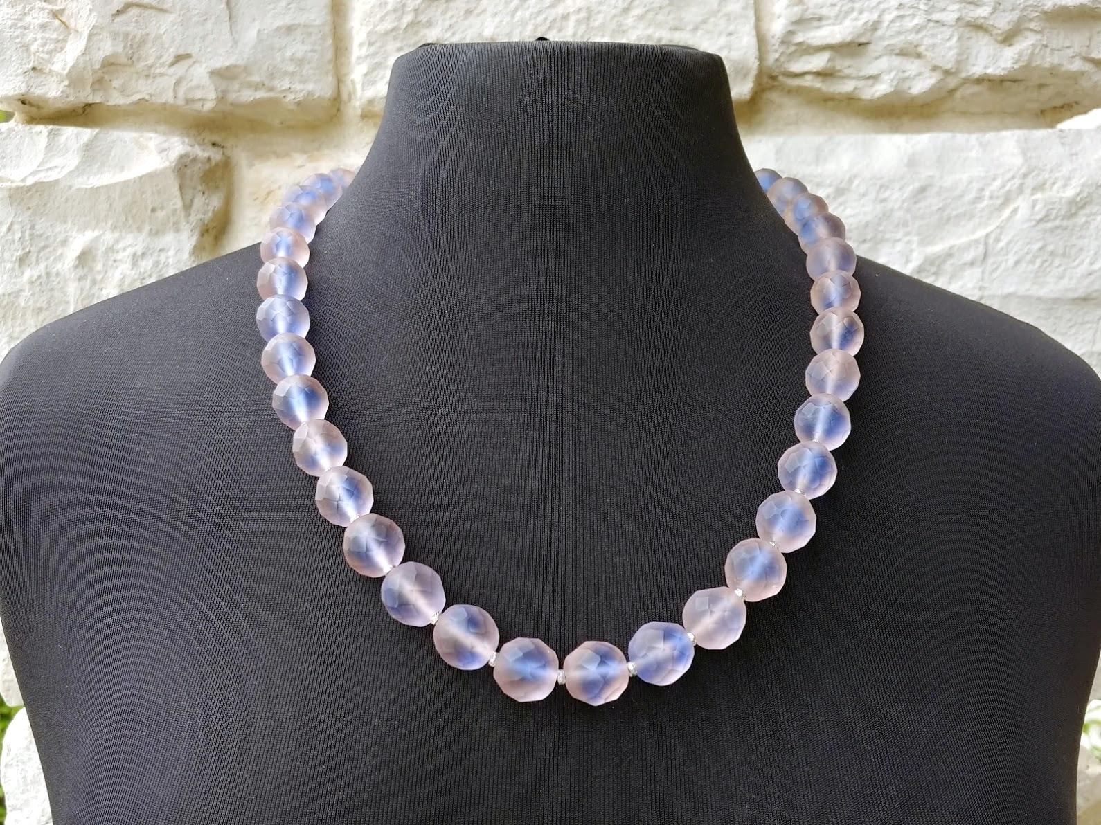 The length of the necklace is 25 inches (63.5 cm). The size of the faceted beads is 14 mm.
A stunning, very pretty vintage strand of old sapphire glass beads. The very light purple-blue bead is faceted with a deep lavender tone towards the center.