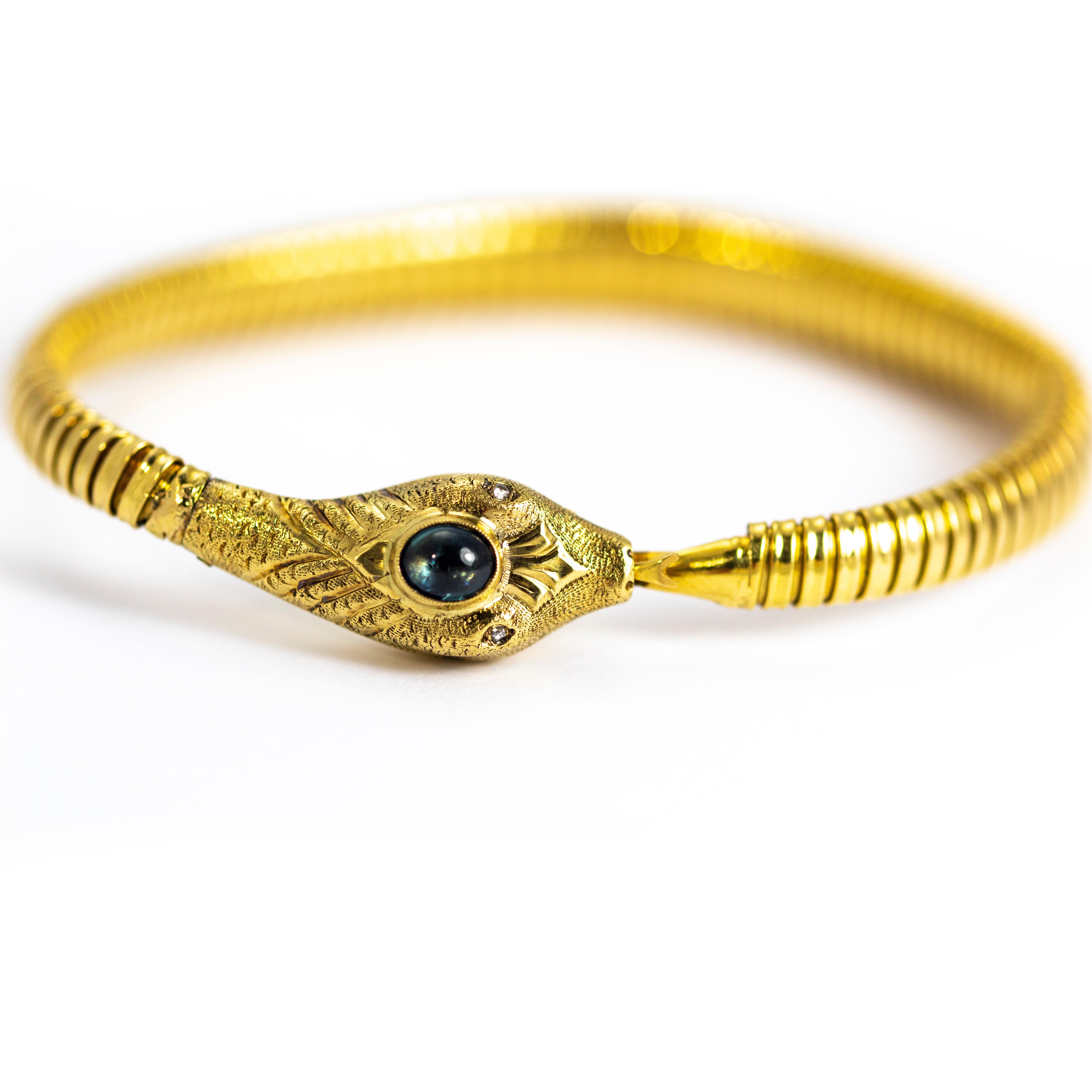 This flexible coiled snake bracelet is fabulous! It holds an oval sapphire cabochon at the centre of its head and has rose cut diamond eyes. The whole of the head has fine engraved detail on it with teeth and textured skin. The most charming detail
