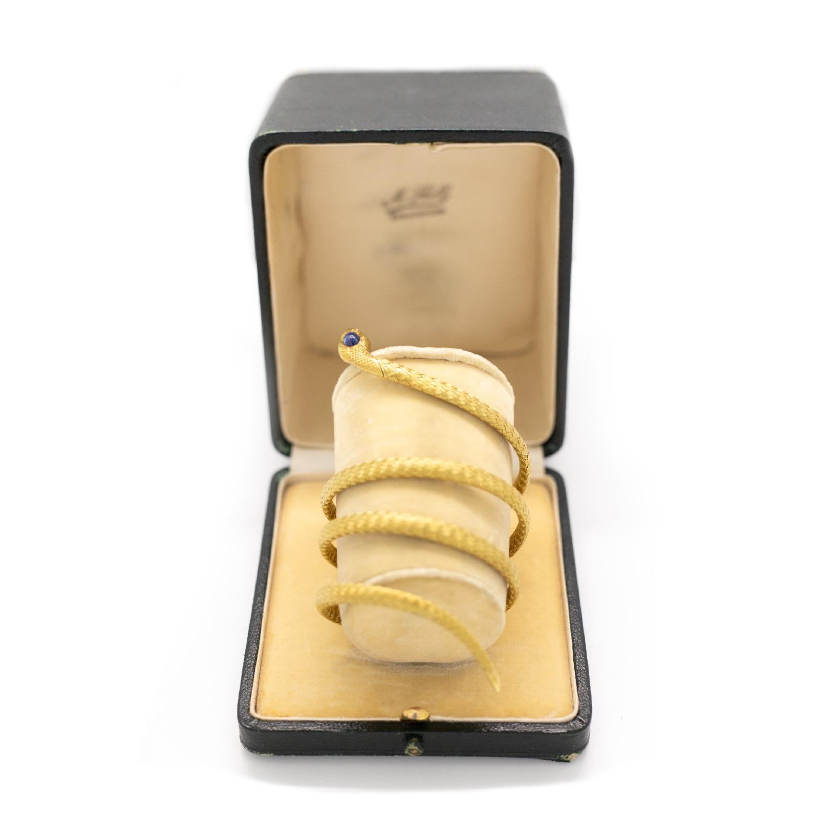 A vintage sapphire and ruby 18 karat yellow gold snake triple coiled flexible bracelet, Circa 1890.

This exceptional antique bracelet is realistically modelled as a coiled snake handcrafted in a braided woven mesh of 18 karat yellow gold. 
The