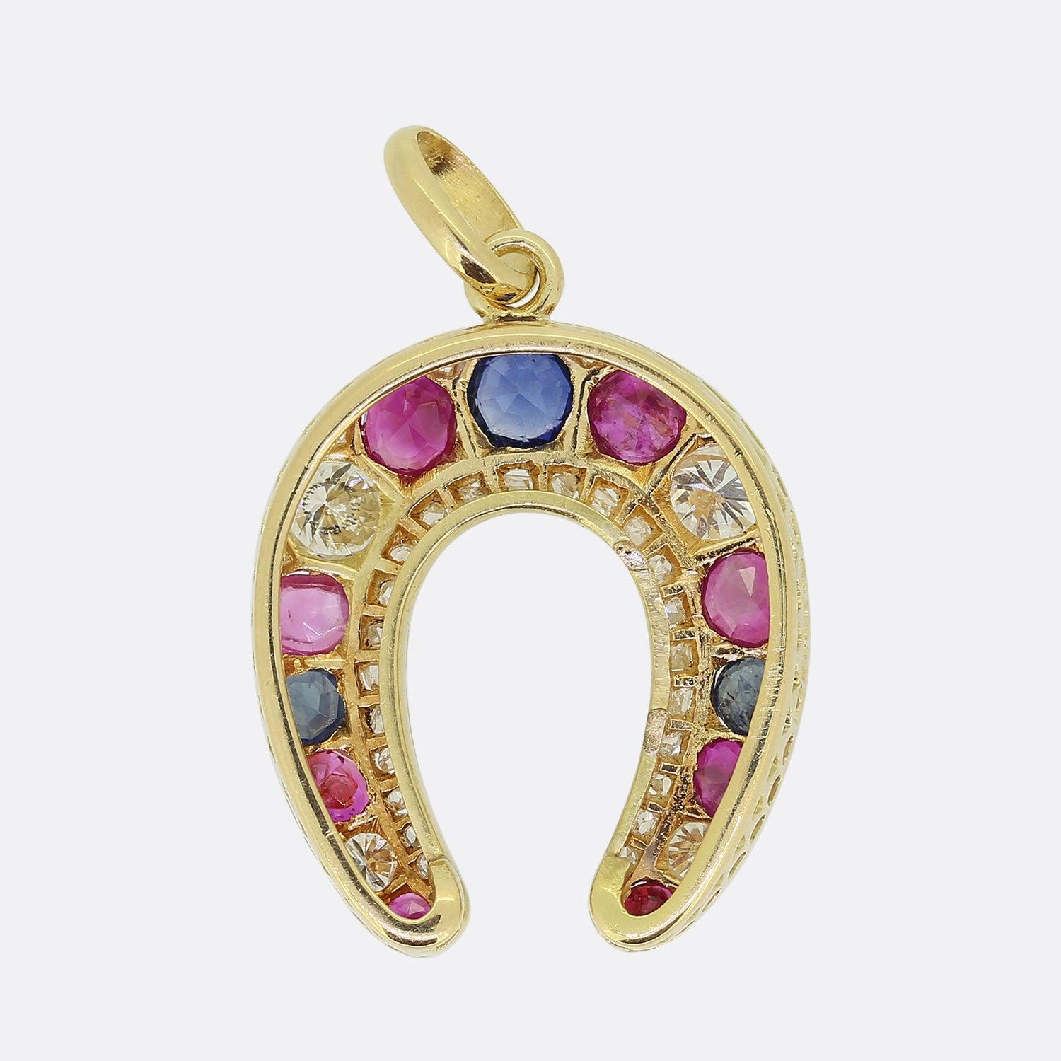 Ecco un meraviglioso ciondolo con più gemme. Questo pezzo vintage è stato realizzato in oro giallo 18 ct a forma di ferro di cavallo, simbolo di fortuna e protezione. In questo caso, un trio di gemme preziose alternate è stato incastonato in una