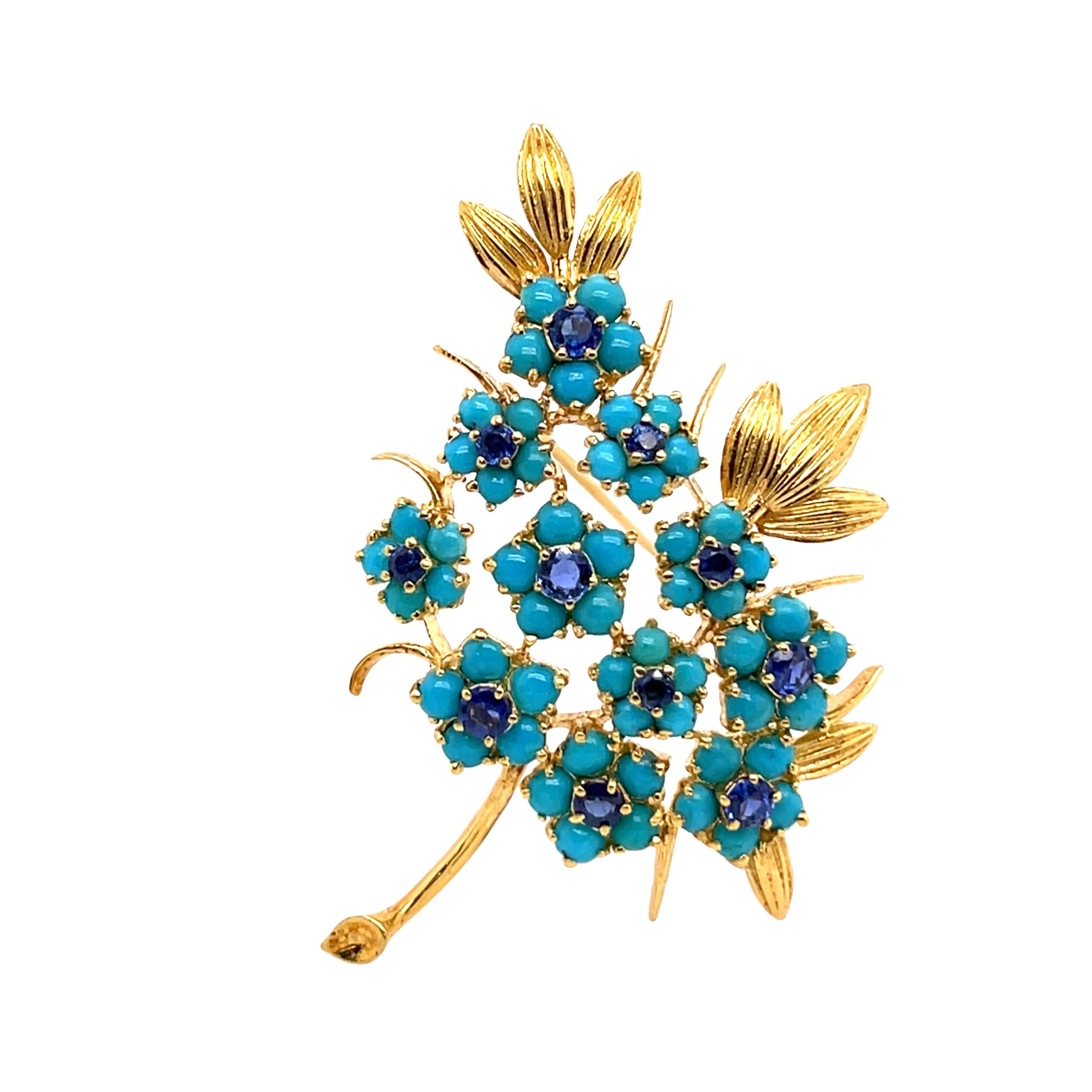 Cette broche vintage exquise est réalisée en or jaune 18 ct et présente une combinaison unique de cabochons de turquoise vibrante et de saphirs bleus étincelants. Une belle représentation de l'élégance du milieu du siècle, idéale pour les