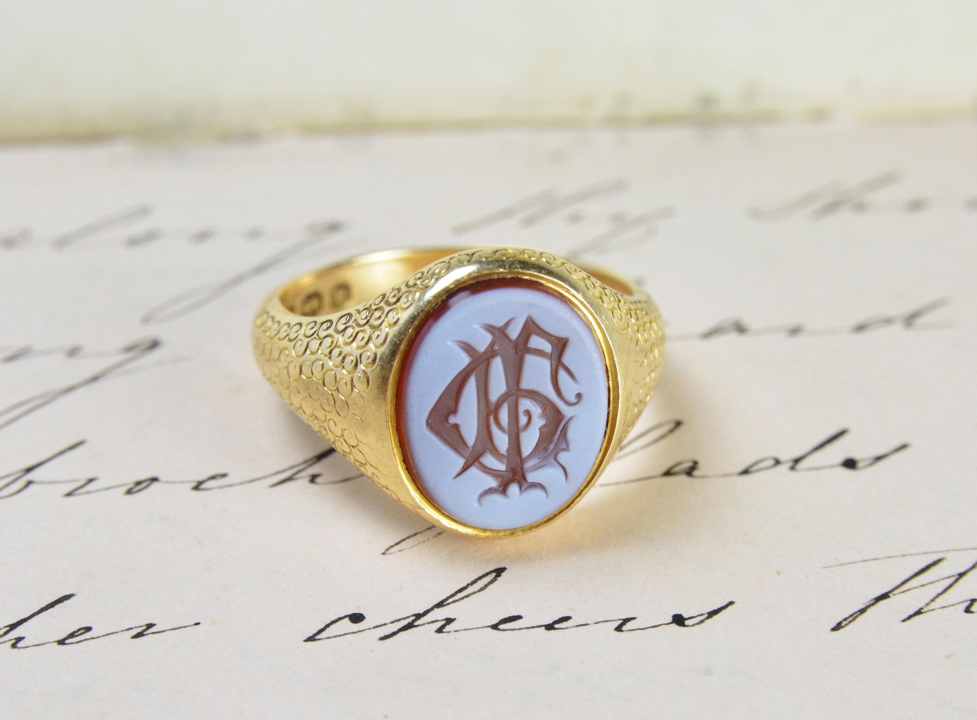 A beautiful example of a red sardonyx Monogram signet ring. The monogram is made up of the letters G R L. The red Sardonyx stone consist of two different coloured strata the top white layer is engraved to reveal the colour underneath.

The ring