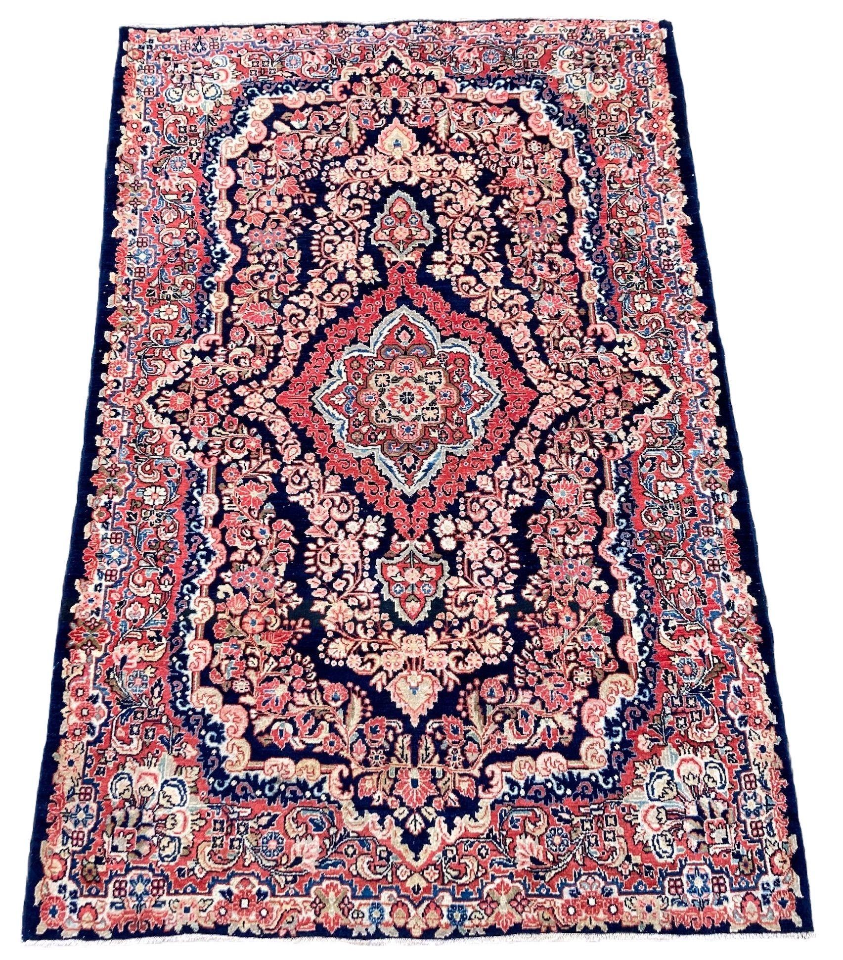 A lovely vintage Sarouk rug, handwoven circa 1940 with a floral medallion on a deep indigo, almost black field surrounded by a free-flowing terracotta border. Finely woven with lovely quality wool and great secondary colours.
Size: 2.06m x 1.35m