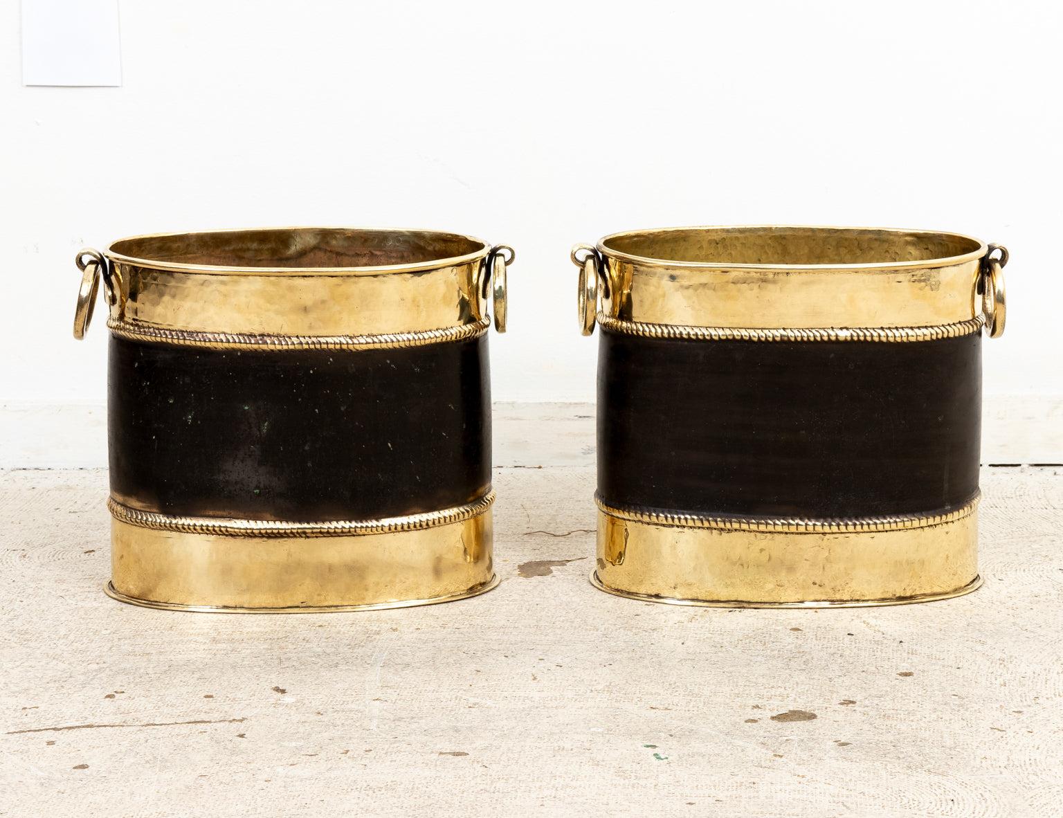 A pair of vintage Sarreid brass and black oval buckets with ring handles on the sides. See Sarreid label on the bottom. Wear consistent with age.