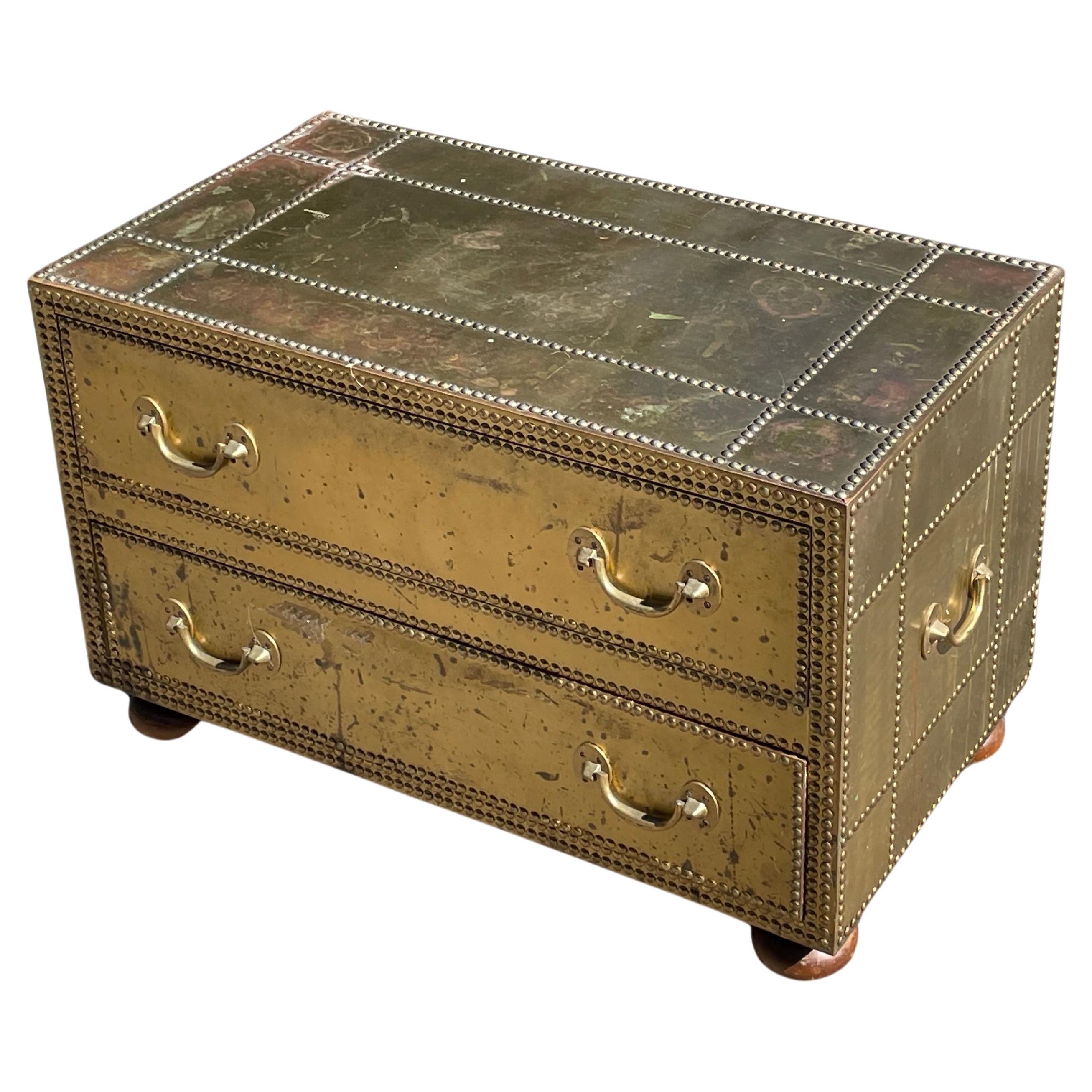 Mesa de cóctel/cómoda glamurosa de dos cajones de mediados de siglo, de Sarreid. Alrededor de 1970.

La mesa de cóctel/cómoda está revestida de latón con adornos de cabeza de clavo. Cajones con cola de milano.

Esta pieza glamurosa combina bien con