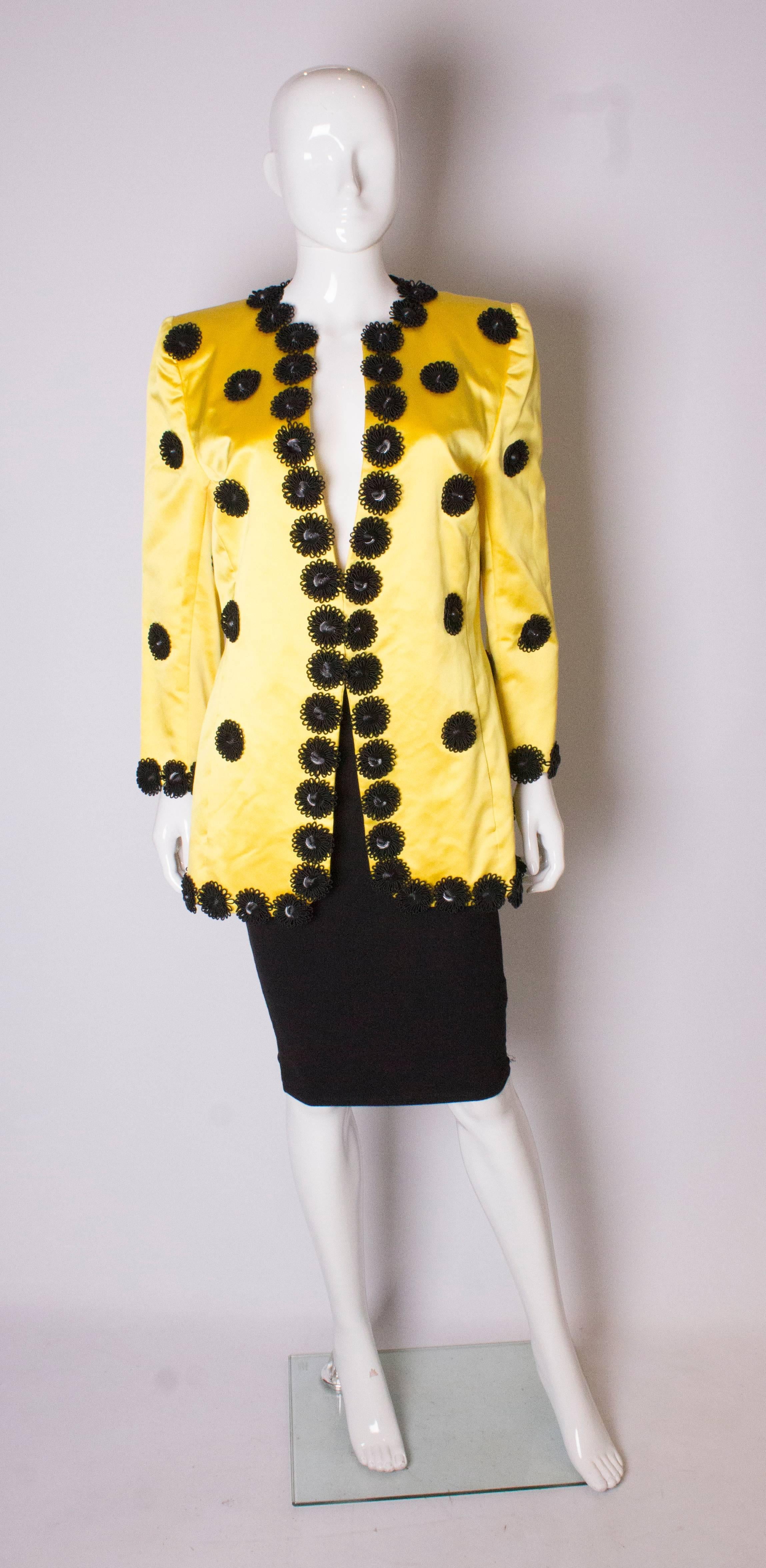 Eine tolle Vintage-Jacke für den Frühling. Die Jacke ist aus gelbem Seidensatin mit schwarzer, blumenartiger Verzierung. Sie ist vollständig gefüttert und hat auf beiden Seiten eine Tasche.
