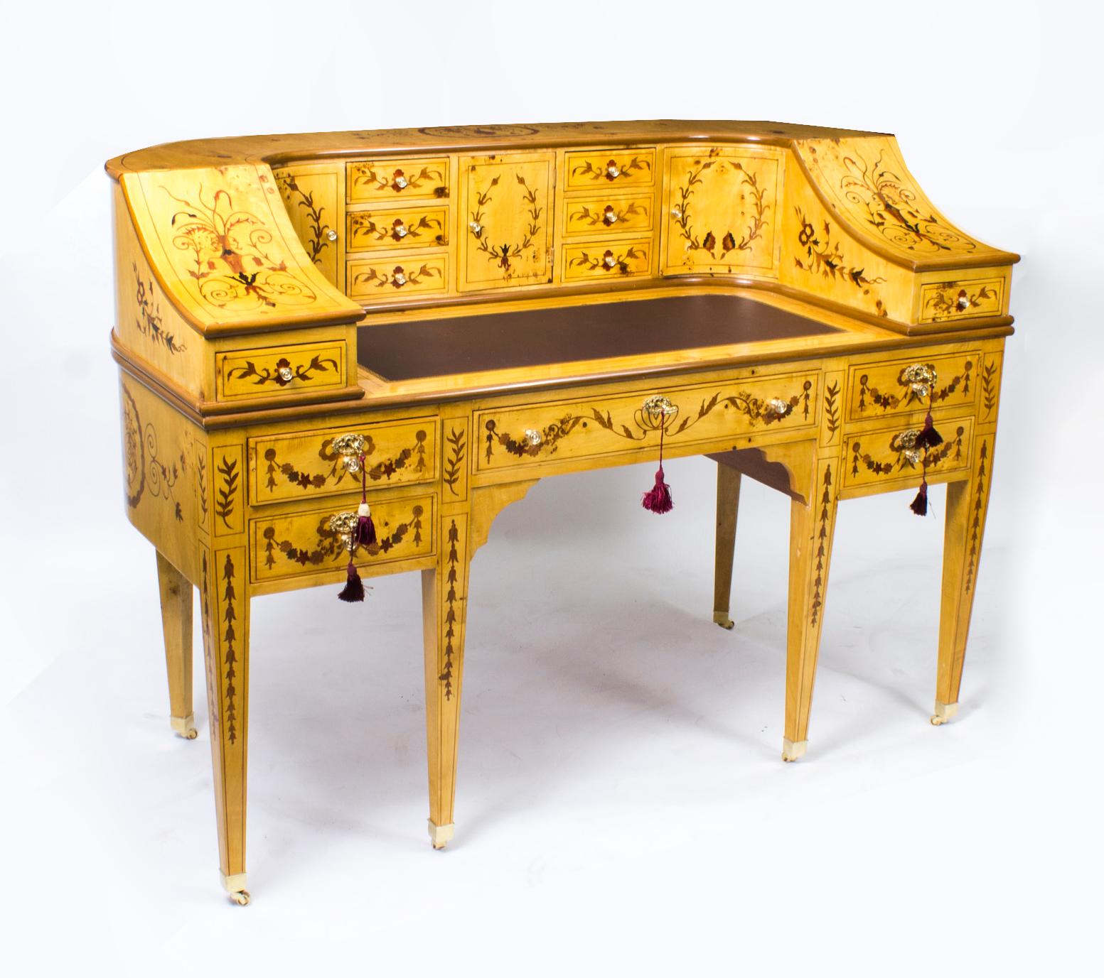 Here we have a very attractive Carlton House Desk which has been hand crafted from the very finest satinwood and decorated with inlaid marquetry and dates from the late twentieth century.
The ornate and fascinating marquetry work includes floral