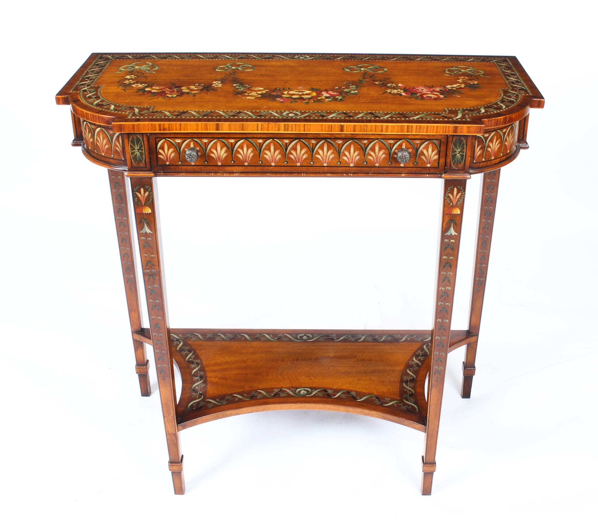 This is a truly magnificent George III style hand-painted satinwood console table, by one of the UKs leading manufacturers of fine furniture, Theodore Alexander, dating from the late 20th Century.

This remarkable console table is made from the