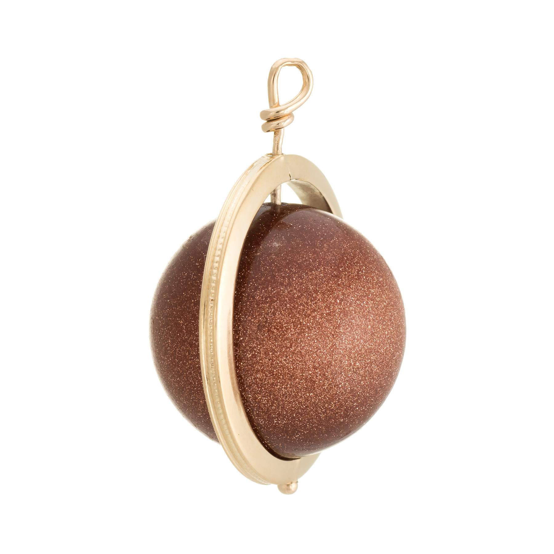 Finely detailed pendant (circa 1960s to 1970s), crafted in 14 karat yellow gold. 

Goldstone measures 19mm. The goldstone is in excellent condition and free of cracks or chips. The goldstone exhibits a glitter in shades of brown and copper.   

The