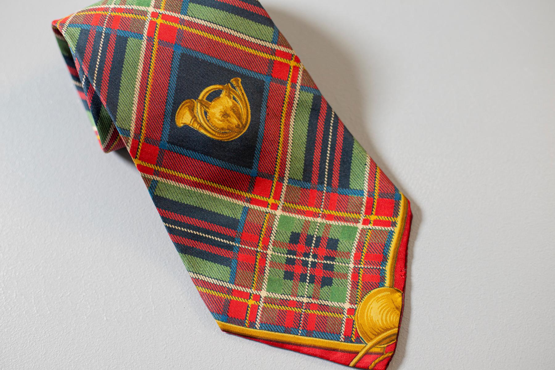 This vintage Saucaldi all-silk tie is a real classic: decorated with a tartan motif, it displays a golden horn and a golden wolf in the middle. This tie is ideal for original and special events.