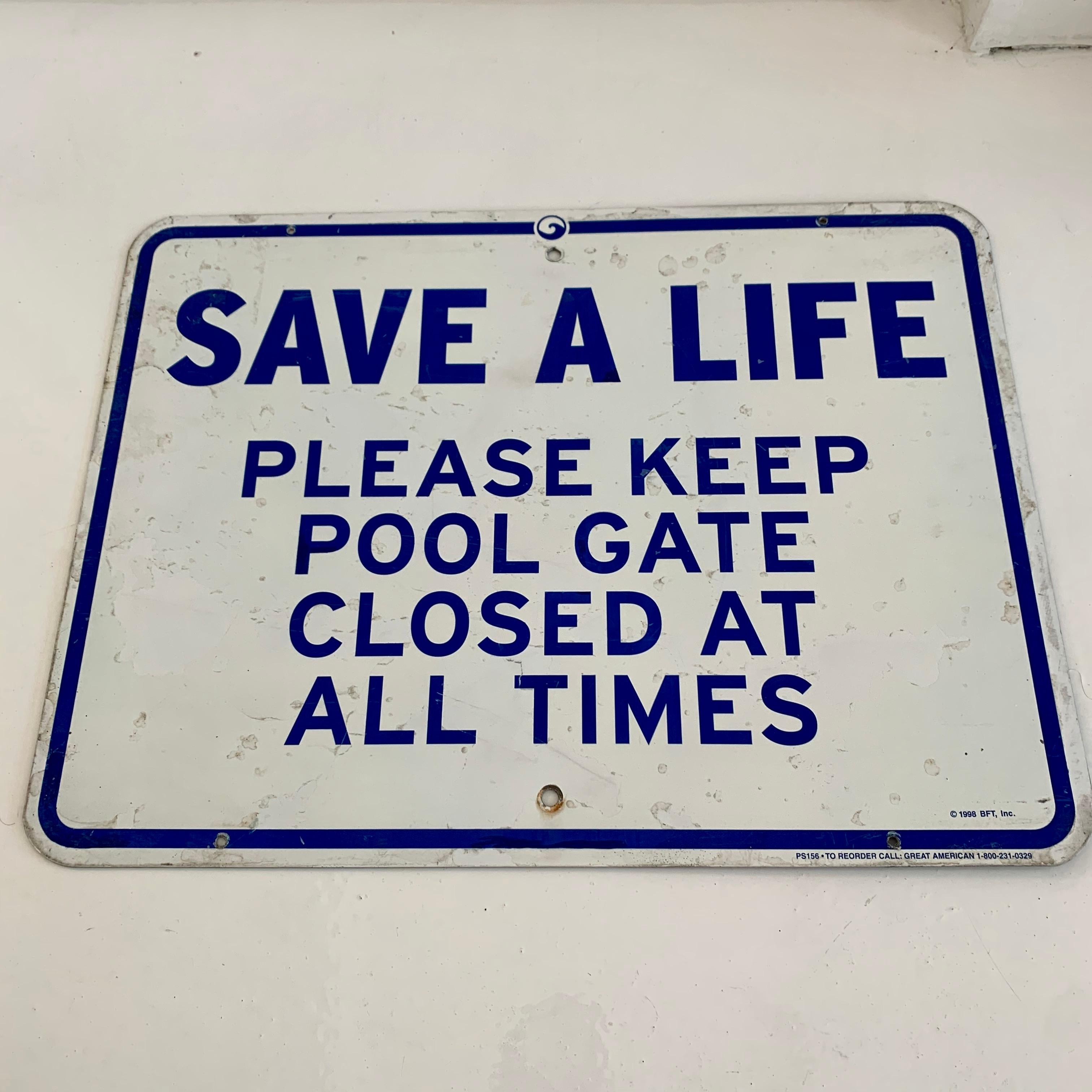 Vintage metal sign from a public pool. White sign with blue lettering. SAVE A LIFE. PLEASE KEEP POOL GATE CLOSED AT ALL TIMES. Good condition with some scratches.