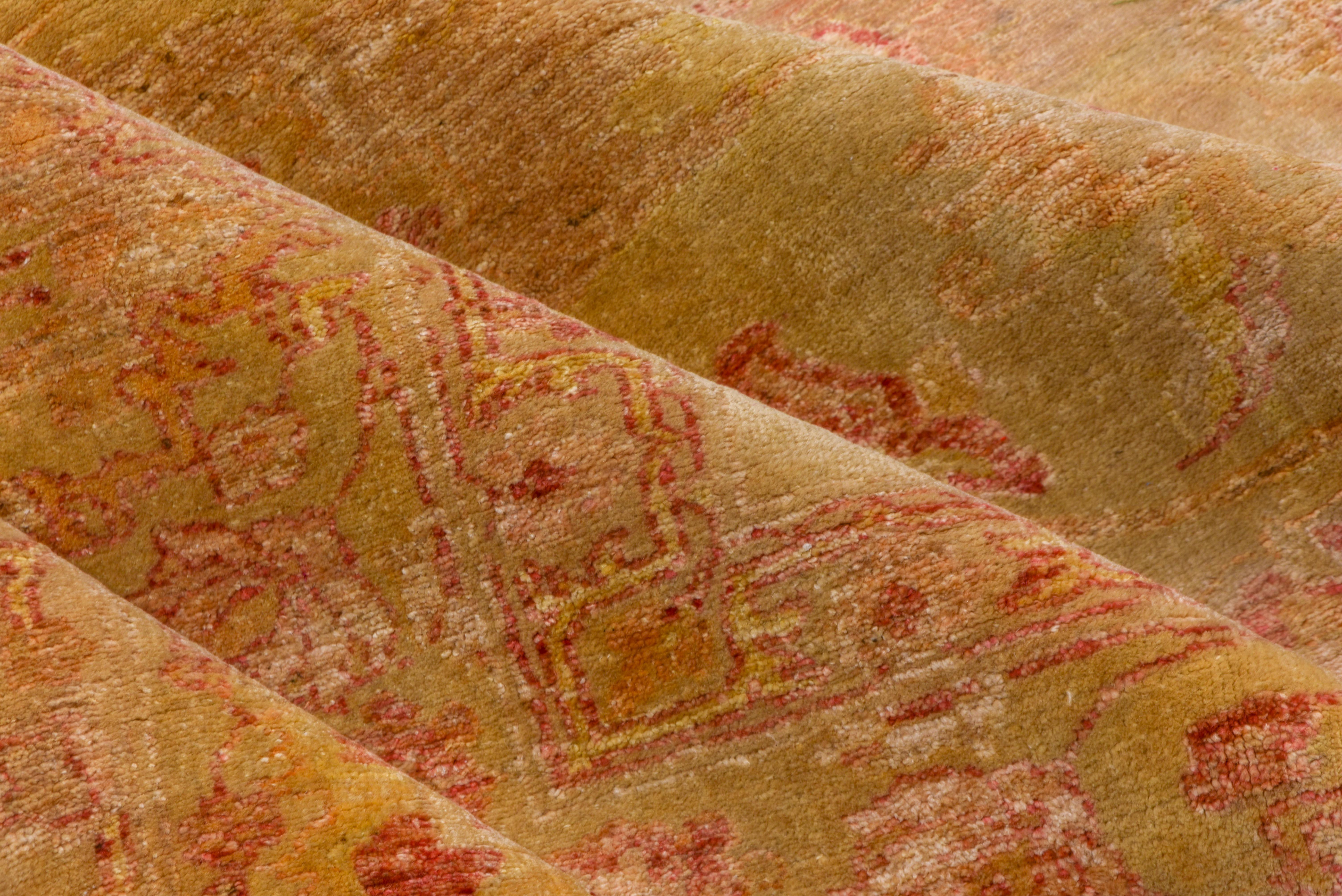 Questo tappeto Savonnerie d'epoca, ricco di dettagli e che mette in mostra l'opulenza delle arti decorative francesi, presenta un gioco armonioso di toni caldi del cammello e del palissandro su tutto il campo, ornato da intricati cartigli pieni di