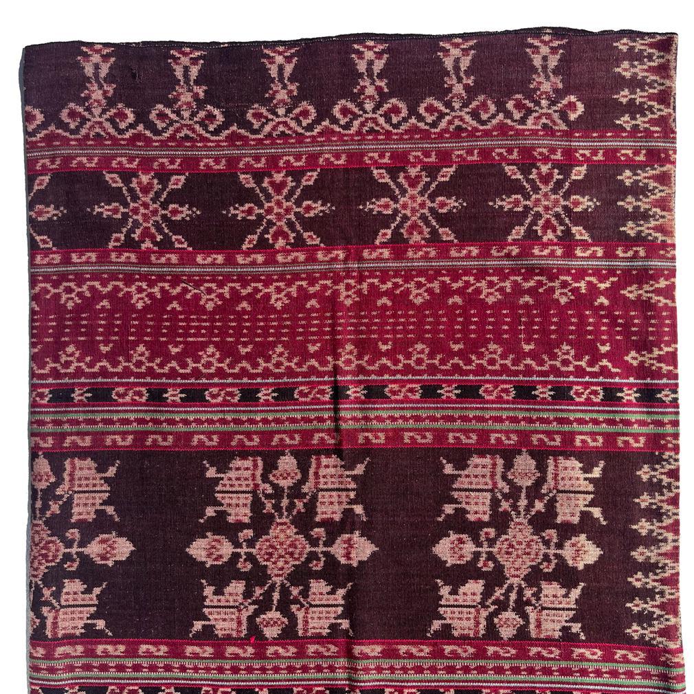 Vintage Savunese Ikat Sarong (Ei), a tubular warp ikat cotton ankle length garment with two large wide decorative bands with five large abstract (Hubi Ae) floral motifs in reserve on a brown ground, interspersed with smaller bands having other