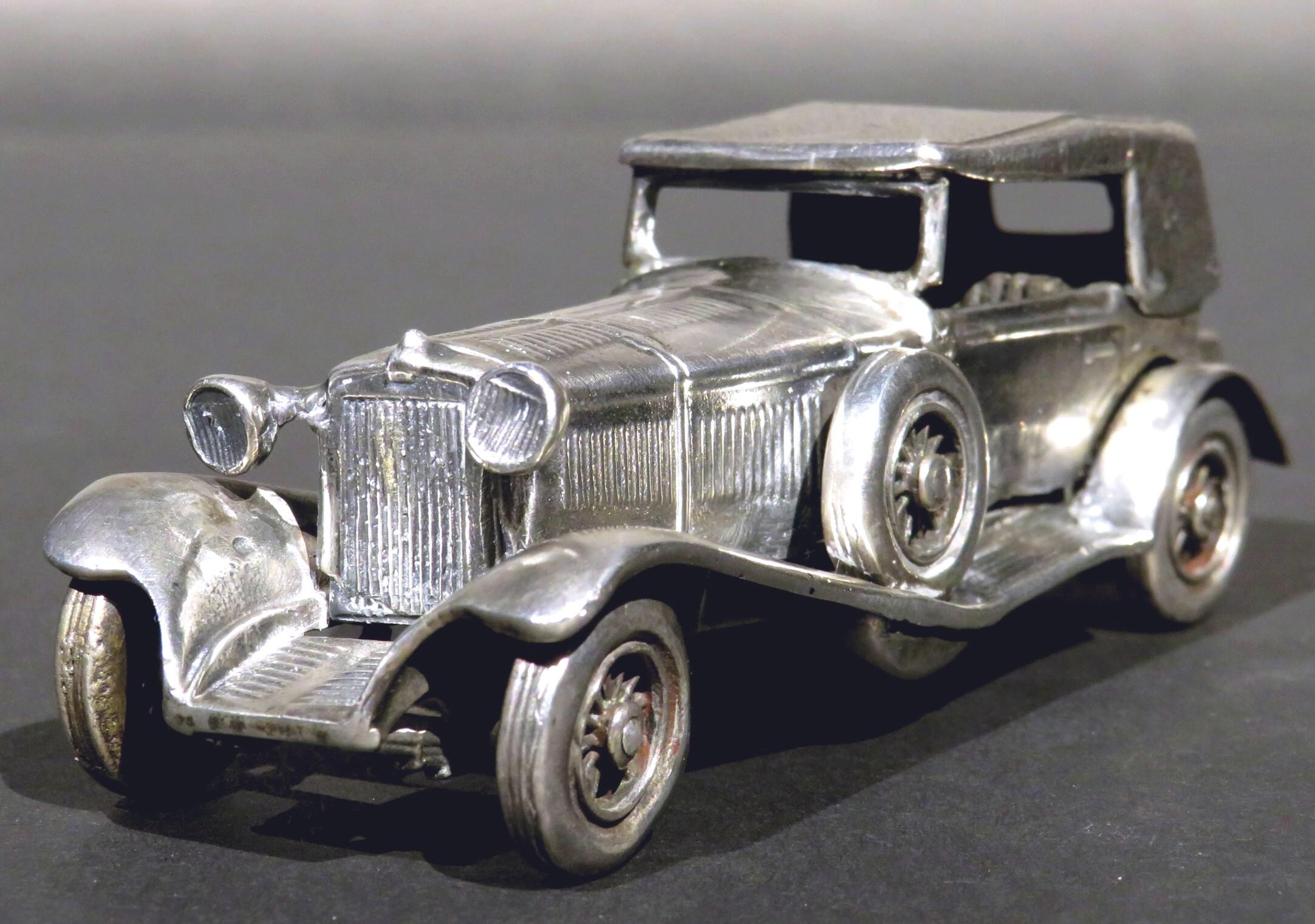 A rare scale model of the classic 1928 Mercedes Benz SS (Super Sport) which was the fastest car of its time. Made entirely of solid silver, the chassis shows a vented & belted hood, rotating wheels, ‘bug eye’ headlights, reeded running boards, a