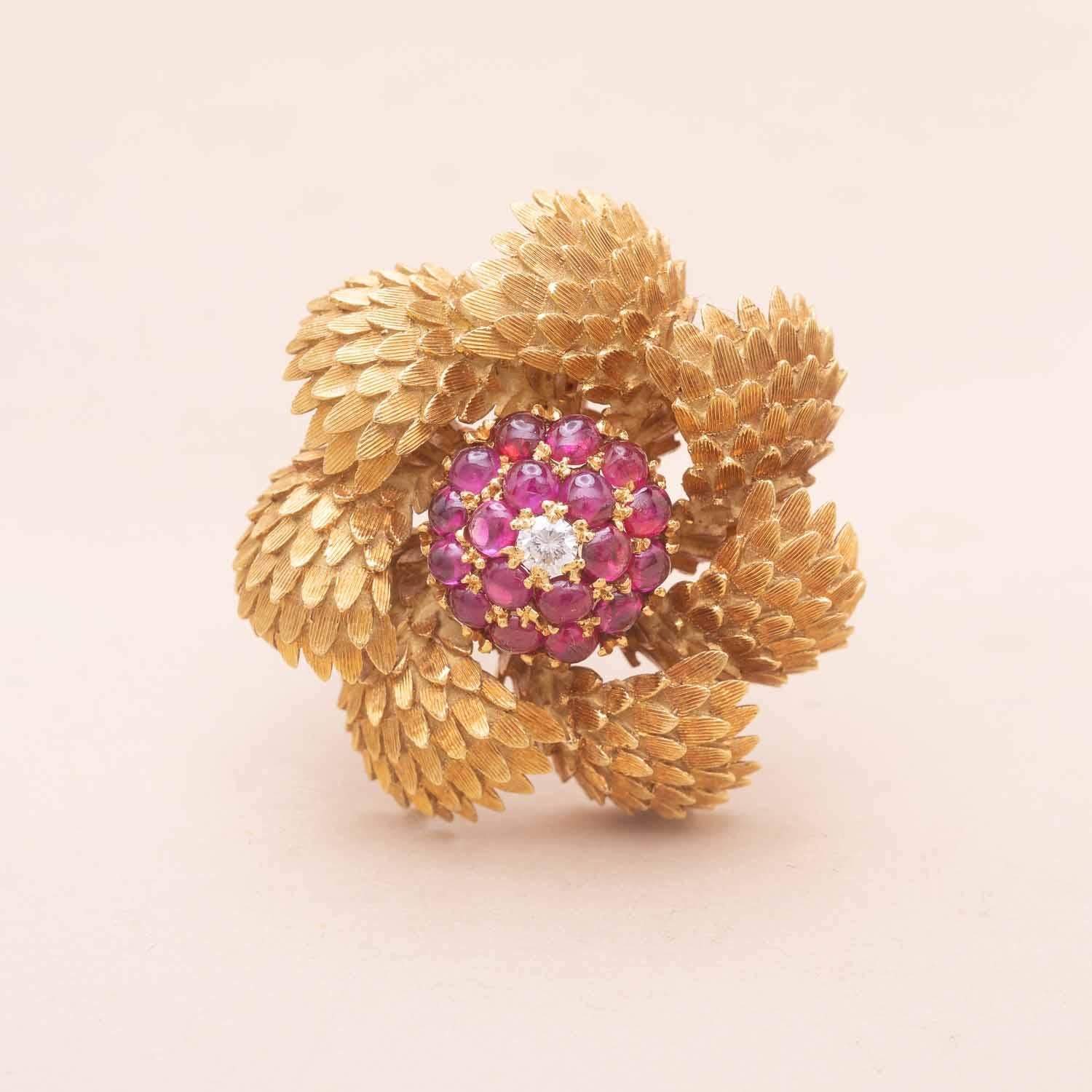 Vintage 18K gold round and spiraling brooch. Engraving forming scales centered by a round-cut diamond and cabochon-cut rubies. 
Birman, non heated rubies 
Diamond's weight : 0.16 carat
1970s Italian Craftsmanship 
750 and weevil hallmark 
Diameter :