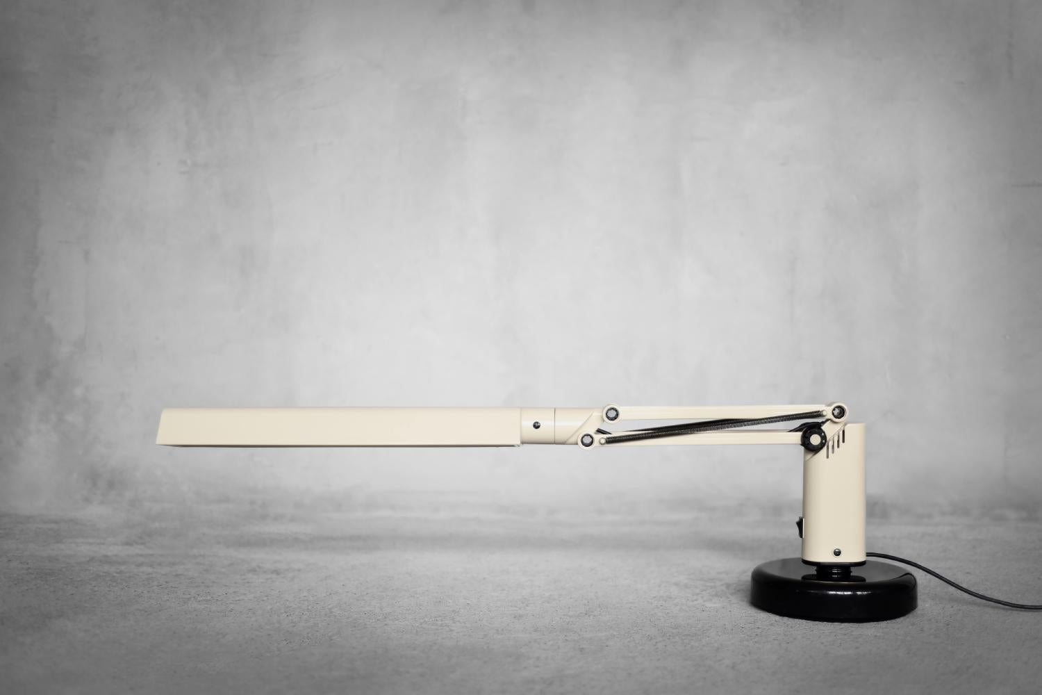 This Lucifer desk lamp was designed by Tom Ahlström and Hans Ehrich for the Swedish manufacturer Fagerhults in 1975. Lucifer has a simple modern design. The lamp is made of ivory and black plastic. It has adjustable height and a mechanism that keeps