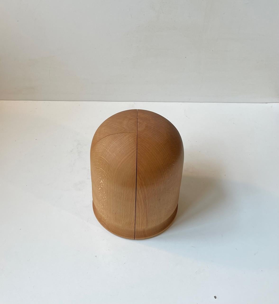A plain professionally made hat head fashioned from 4 solid lumps of pine. It has a center-screw and is adjustable to the sides expanding the circumference. Custom-made by unknown HVF. Measurements: H: 19 cm, Diameter: 16 cm (fully screwed together).