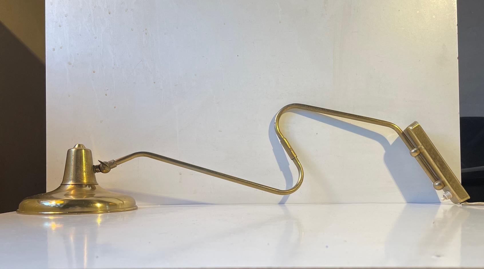 Fully adjustable wall lamp fully made in brass. Its adjustable to both sides, in dept/reach and at the shade. It was designed and manufactured by Laoni in Copenhagen, Denmark. The style is reminiscent of Svend Aage Holm-Sørensen and Paavo Tynell.