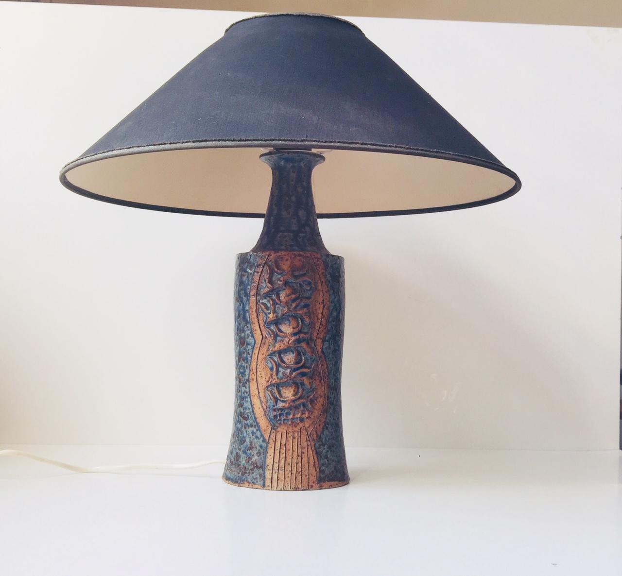 Exceptional table lamp by an anonymous Scandinavian ceramist. It features delicate blue textured glaze reminiscent of Gunnar Nylund and architectural features to the exposed and textured center. It is signed to the inside of the base. The black