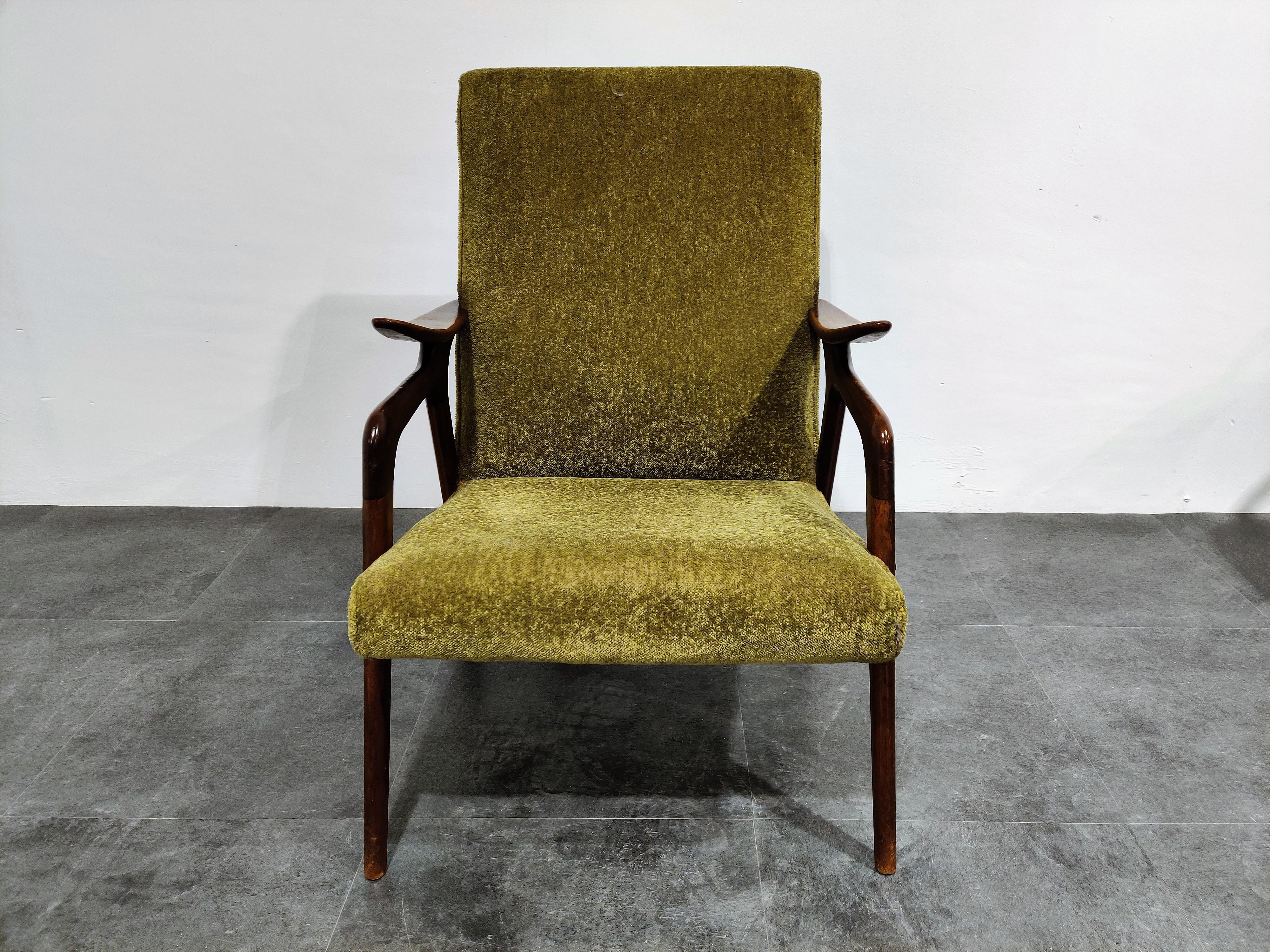 Elegant teak wooden armchair with it's original olive green fabric upholstery.

The chair is in good condition.

Lovely and unique armrests.

1960s, Denmark?

Height 89cm/35.03