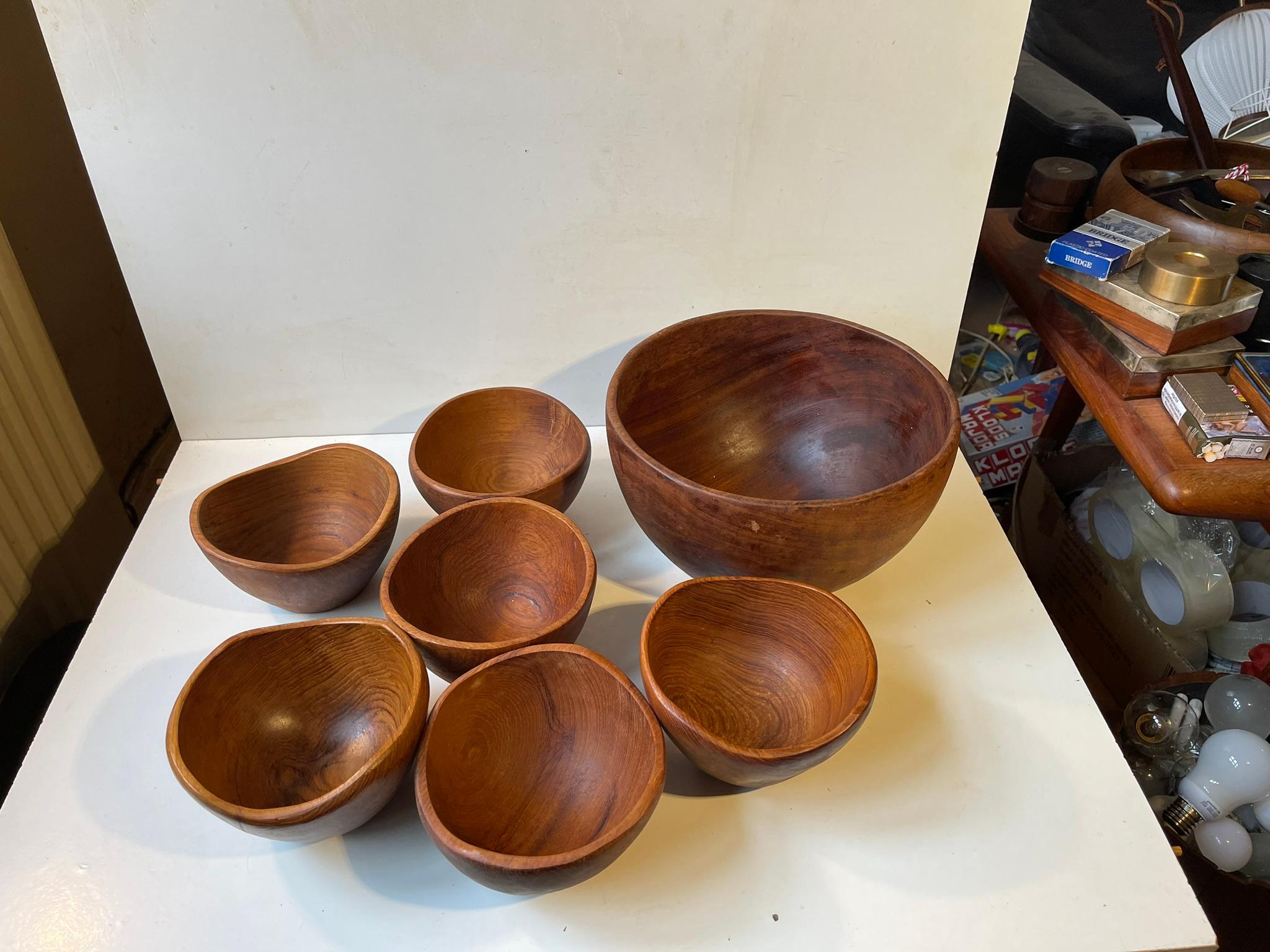 Unusual asymmetrical bowls in solid teak. The set consist of a salad bowl and 6 matching portion bowls. Beautiful hand-finished organic shape with soft curves. Made in-house at ESA Møller in Denmark during the 160s in a style reminiscent of Finn