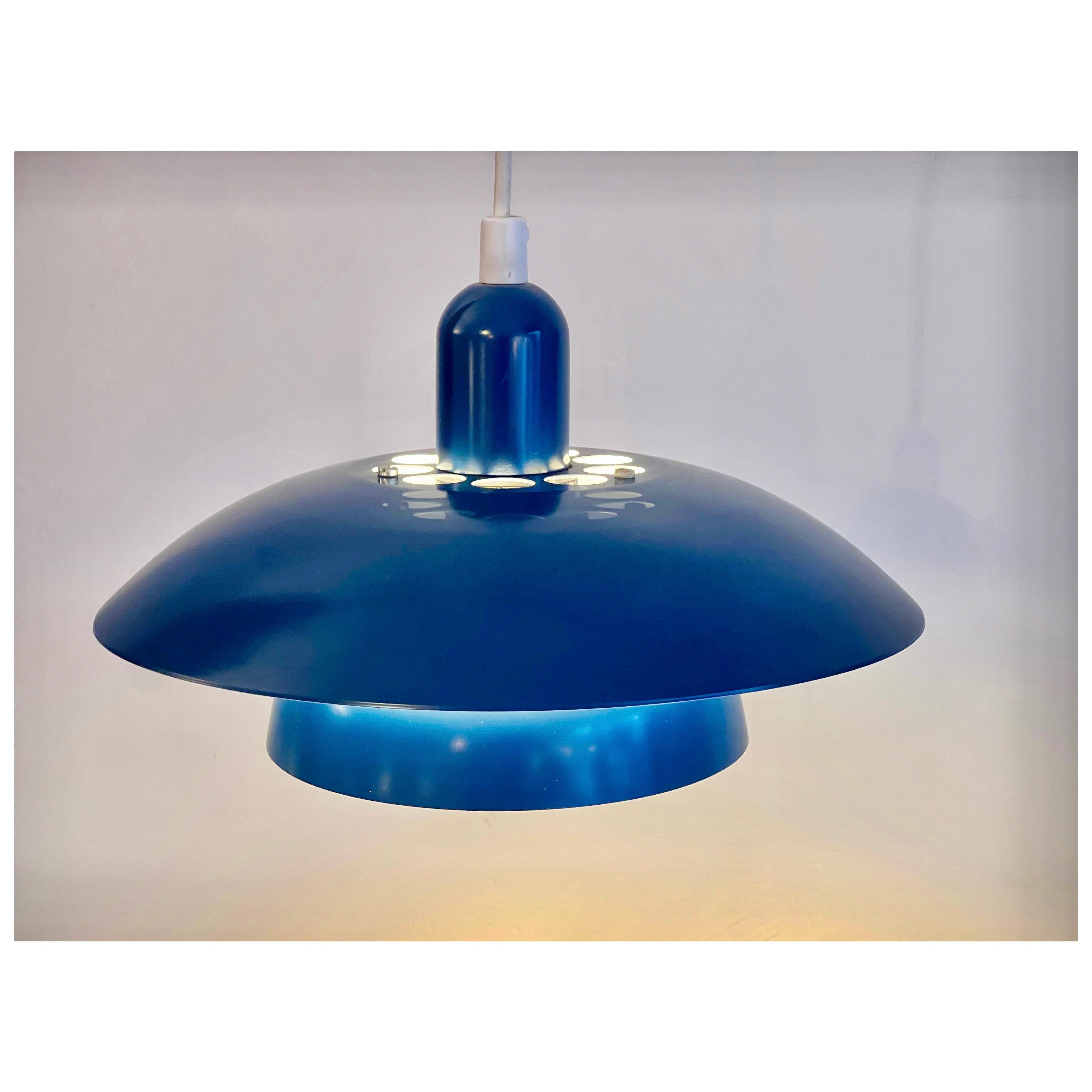 Small Scandinavian pendant lamp in an electric blue!  
The different layers and the circular holes on the top provide a nice play of light and shadow, also on the adjacent walls and ceiling!  
Blue outside, white inside  Smaller format, very