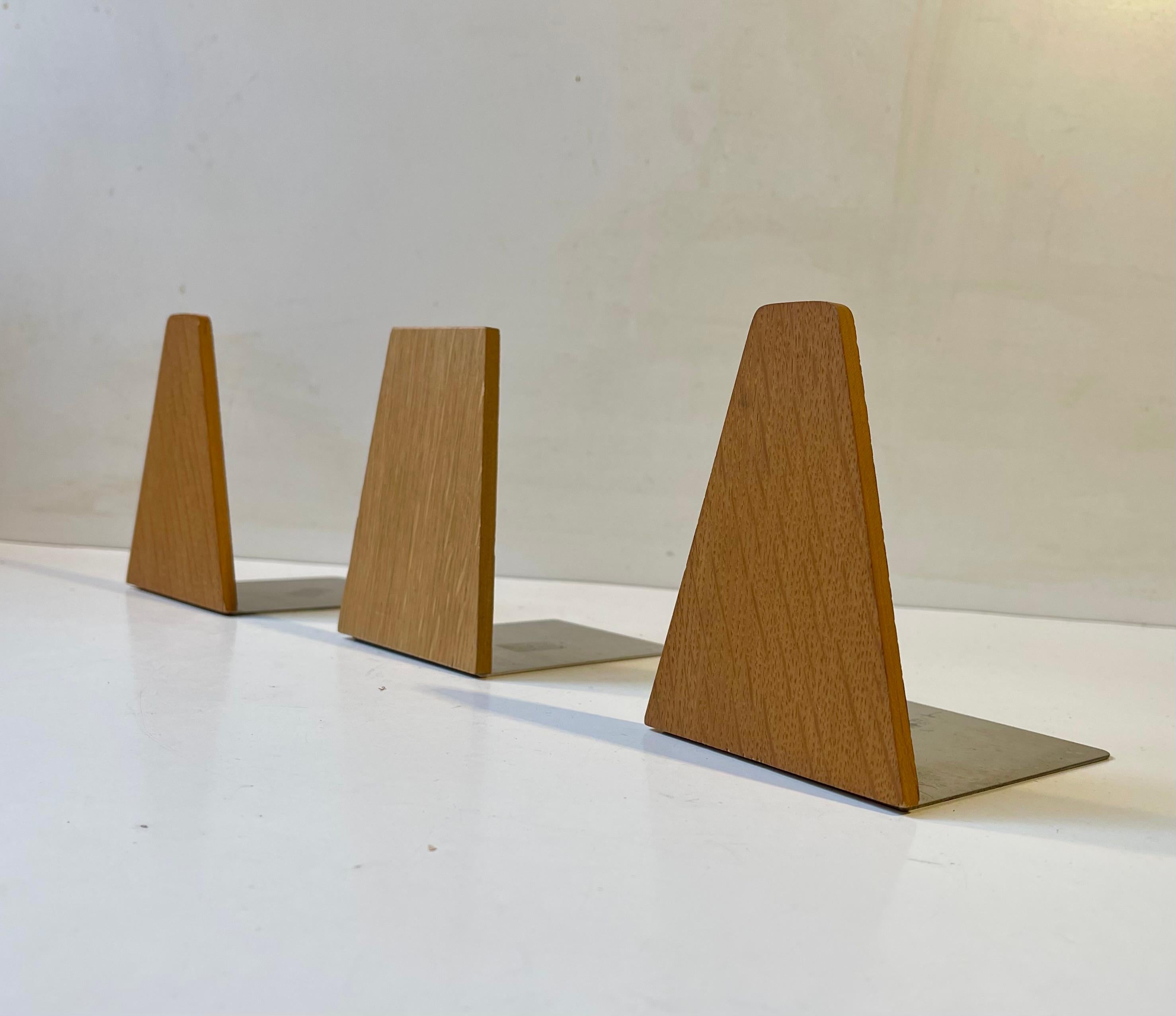 Un set di 3 reggilibri in teak con base in metallo, probabilmente prodotti da FM Møbler o ESA Denmark negli anni Sessanta. 

Misure: Altezza: 12 cm, Diametro: 11 cm.