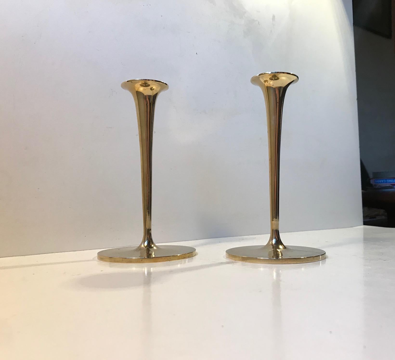 A pair of solid brass candlesticks manufactured in Scandinavia during the 1960s. The candlesticks are to be fitted with regular sixed candles. They have not been polished recently and display patina. The style of this set is reminiscent of