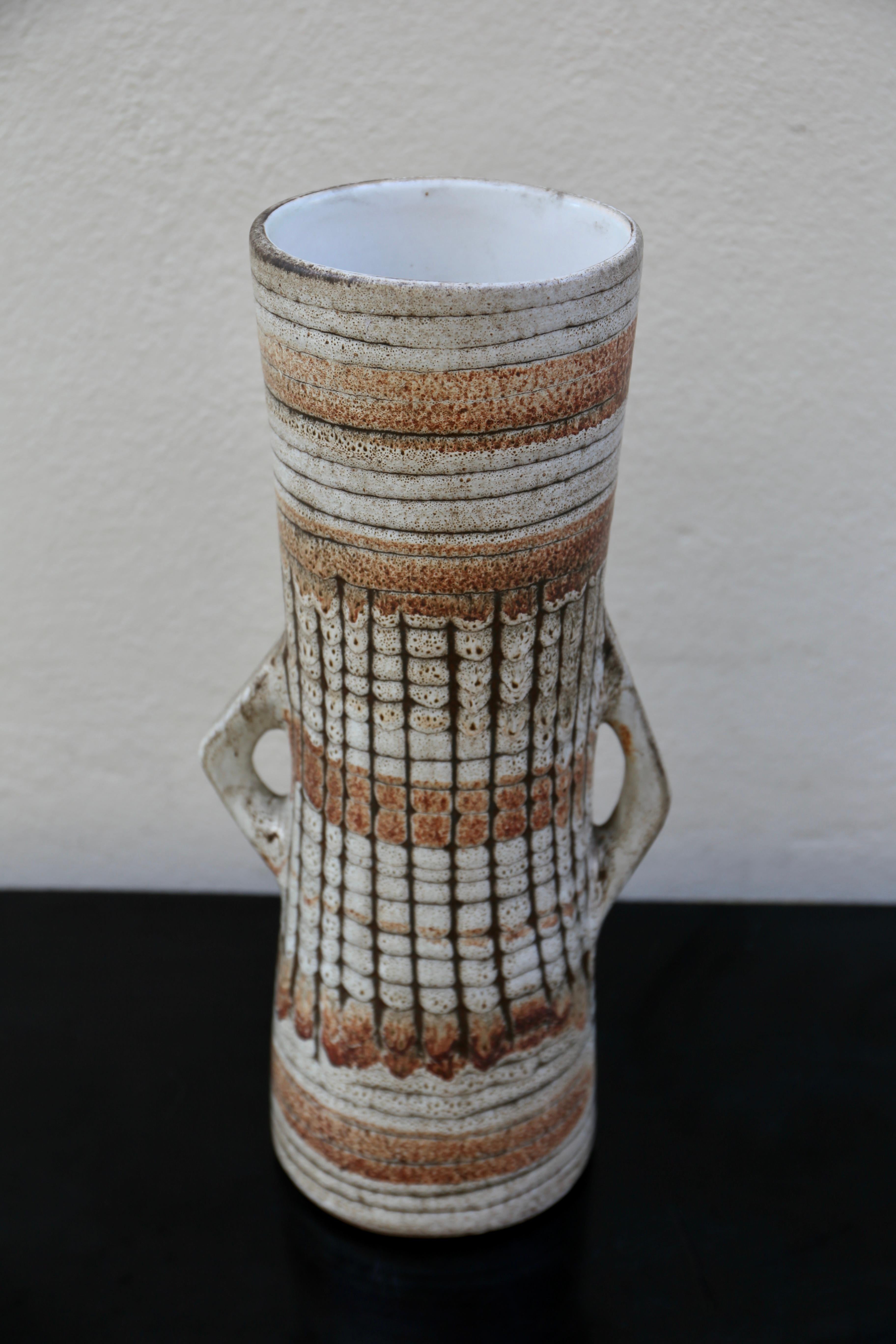 This impressive ceramic vase dates to the mid century.Loosely brushed characters decorate the shoulders and sides, painted in warm browns atop a creme-white slip base.The large vase has only become more beautiful with age, a testament to the