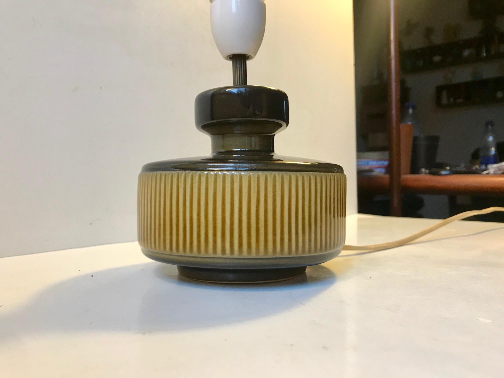 Small Danish pottery table lamp with pickles green glaze and a center decor in yellow stripes. This particular one was manufactured by Søholm in Denmark during the 1970s. Please notice that this light comes without the shade. Please personalize with