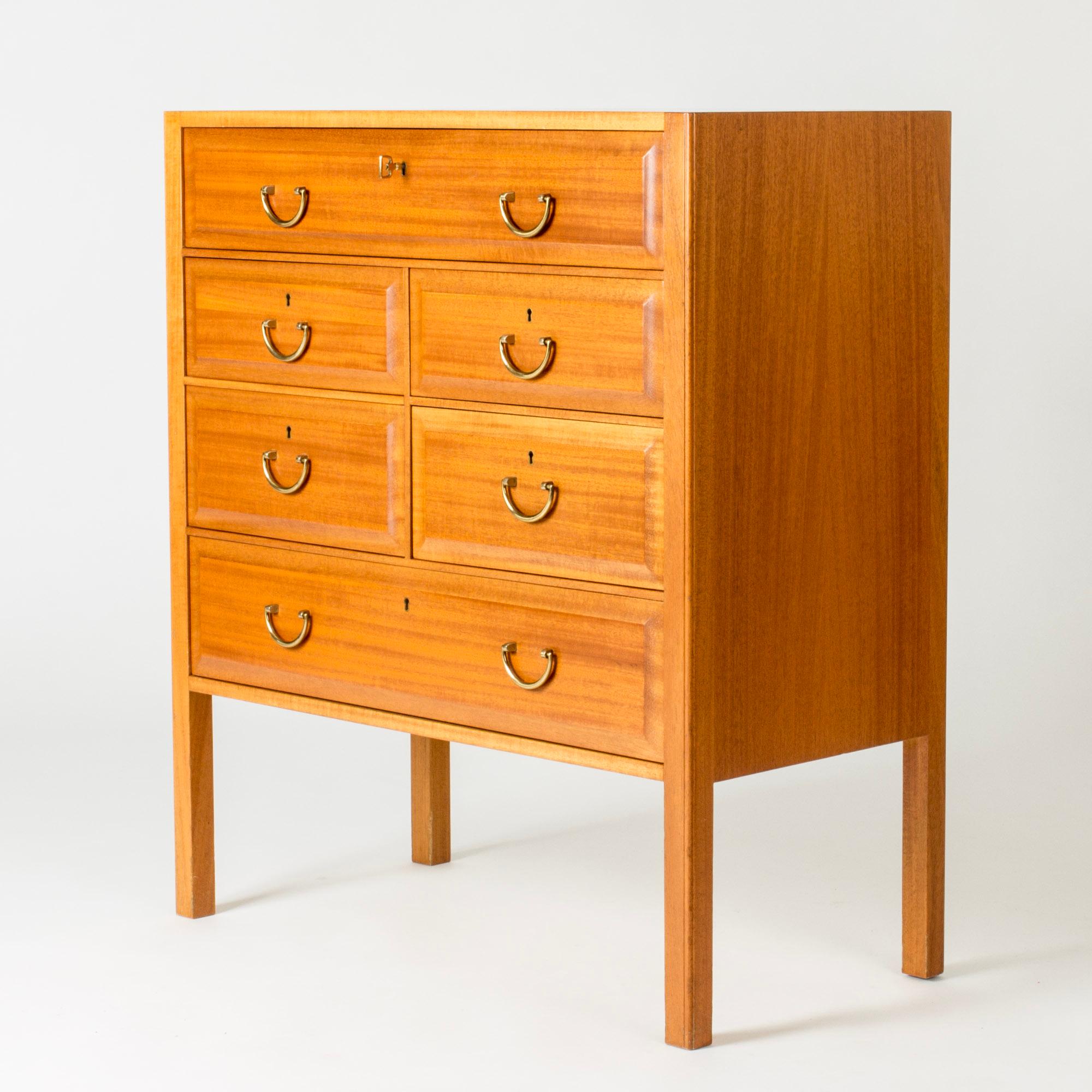 Elegant chest of drawers by Josef Frank, made from mahogany. Beveled edges around the drawers, brass handles. Lighter wood stripe inlayed around the edge of the table top.