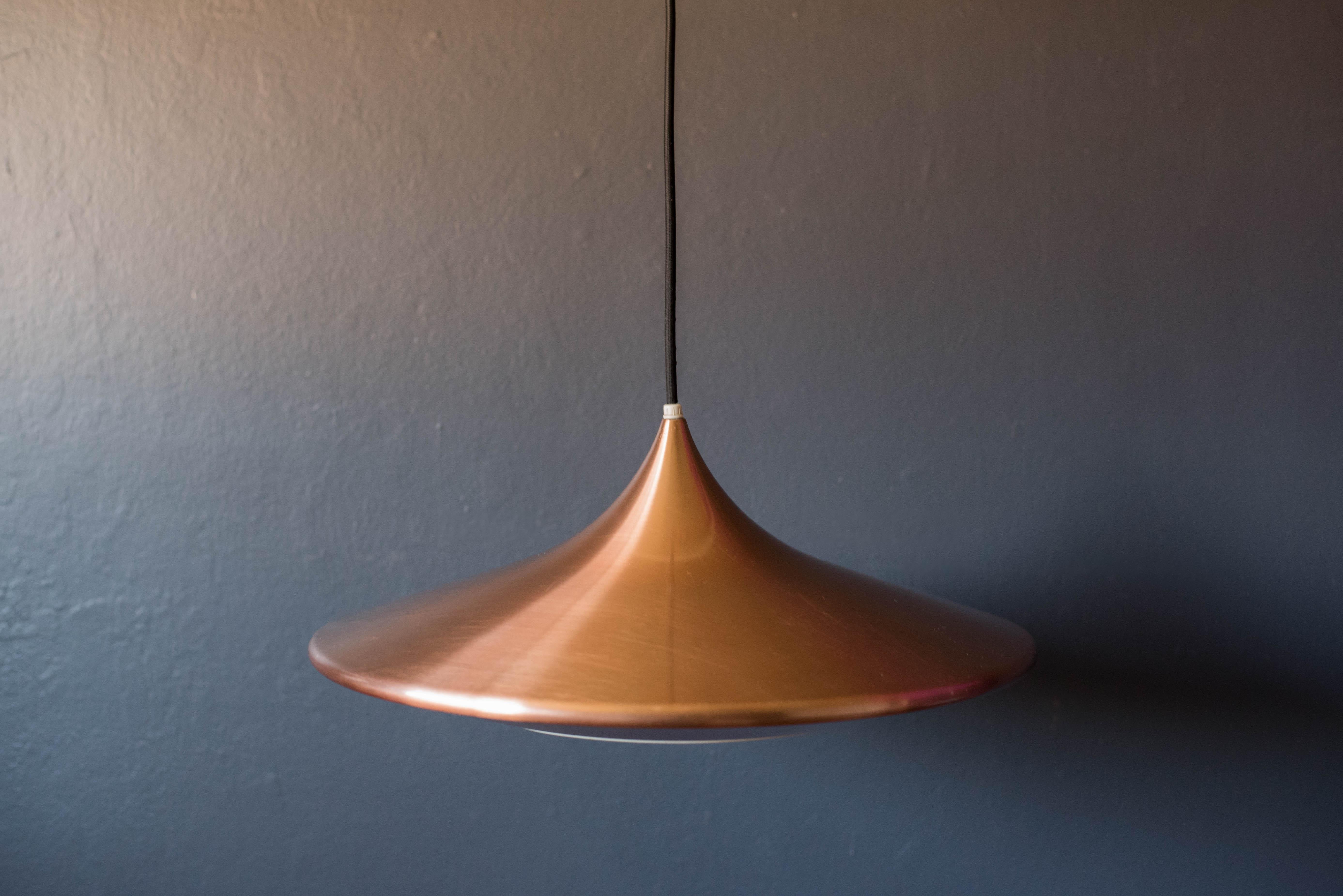 Mid-Century Modern hanging saucer pendant lamp c. 1960's. This sculptural piece has a shiny copper plated finish and includes a white bakelite diffuser. 

Black cord: 60