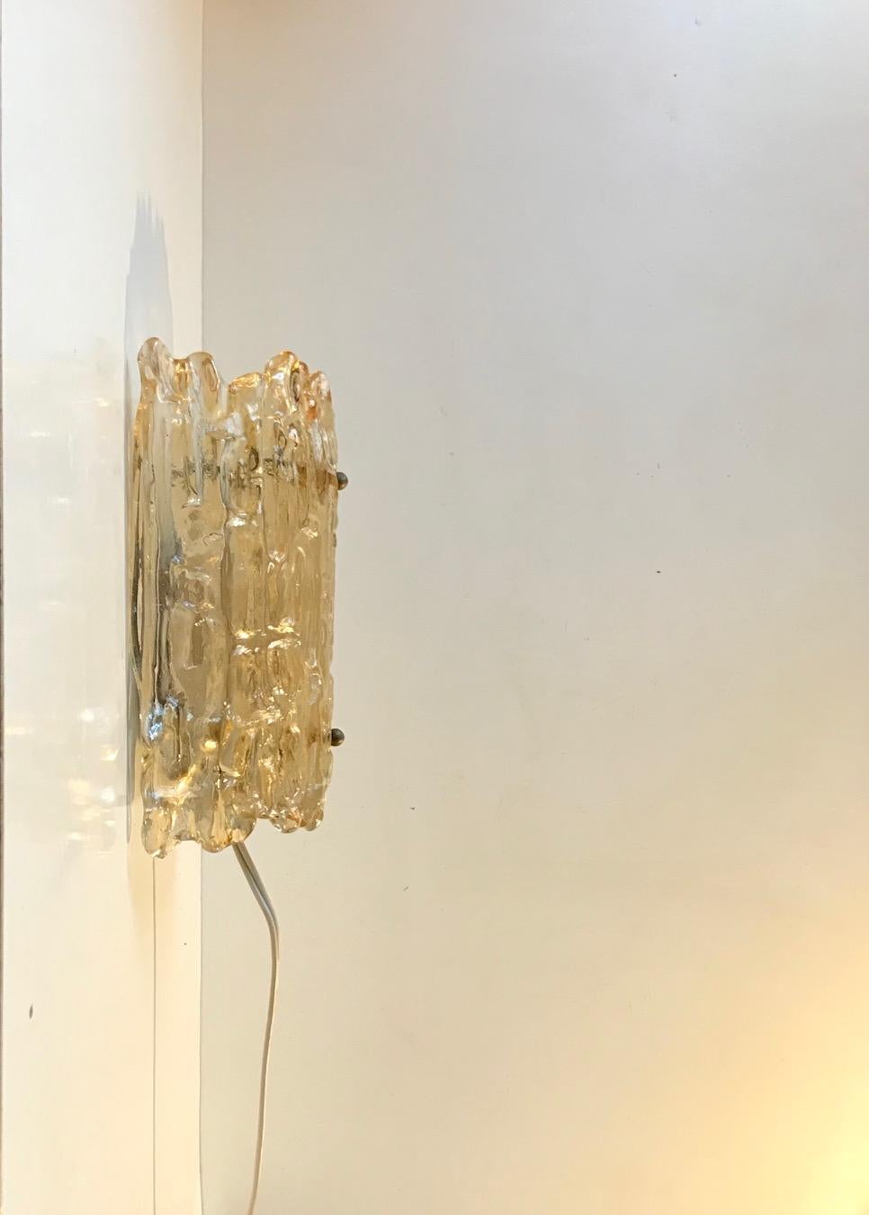 Scandinavian art glass wall light attributed to Carl Fagerlund and manufactured by Orrefors in Sweden during the 1950s-60s. The textured crystal shade creates a cosy, ambient and soft lighting.