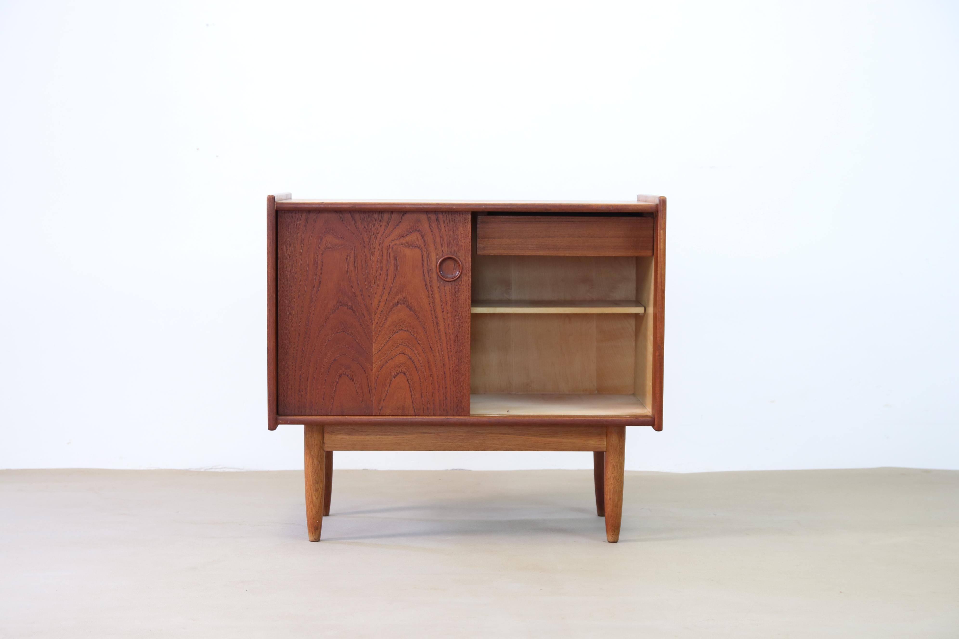 Very nice cabinet from Denmark in the style of Borge Mogensen and Finn Juhl. Made of teak and oak. The cabinet has two sliding doors with a beautiful drawing in the wood. There is also a drawer behind a sliding door. This box is not that big, so it